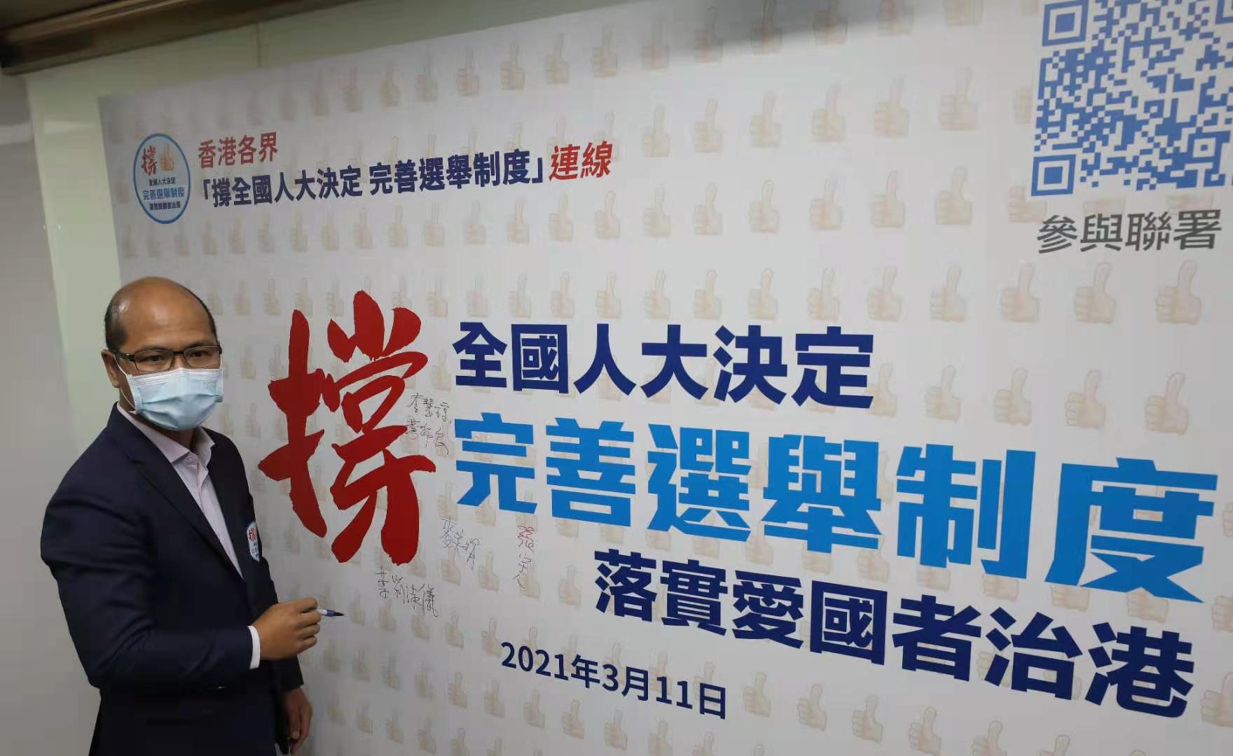 香港教育工作者聯會主席黃錦良簽名支持全國人大通過關於完善香港特別行政區選舉制度的決定。(香港文匯報記者 北山彥攝)