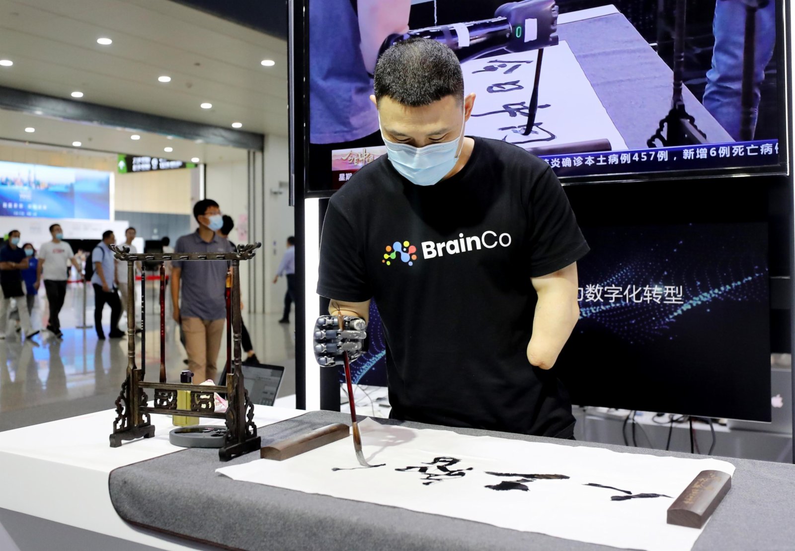 展方工作人員在演示使用倣生機械手寫書法。(新華社)