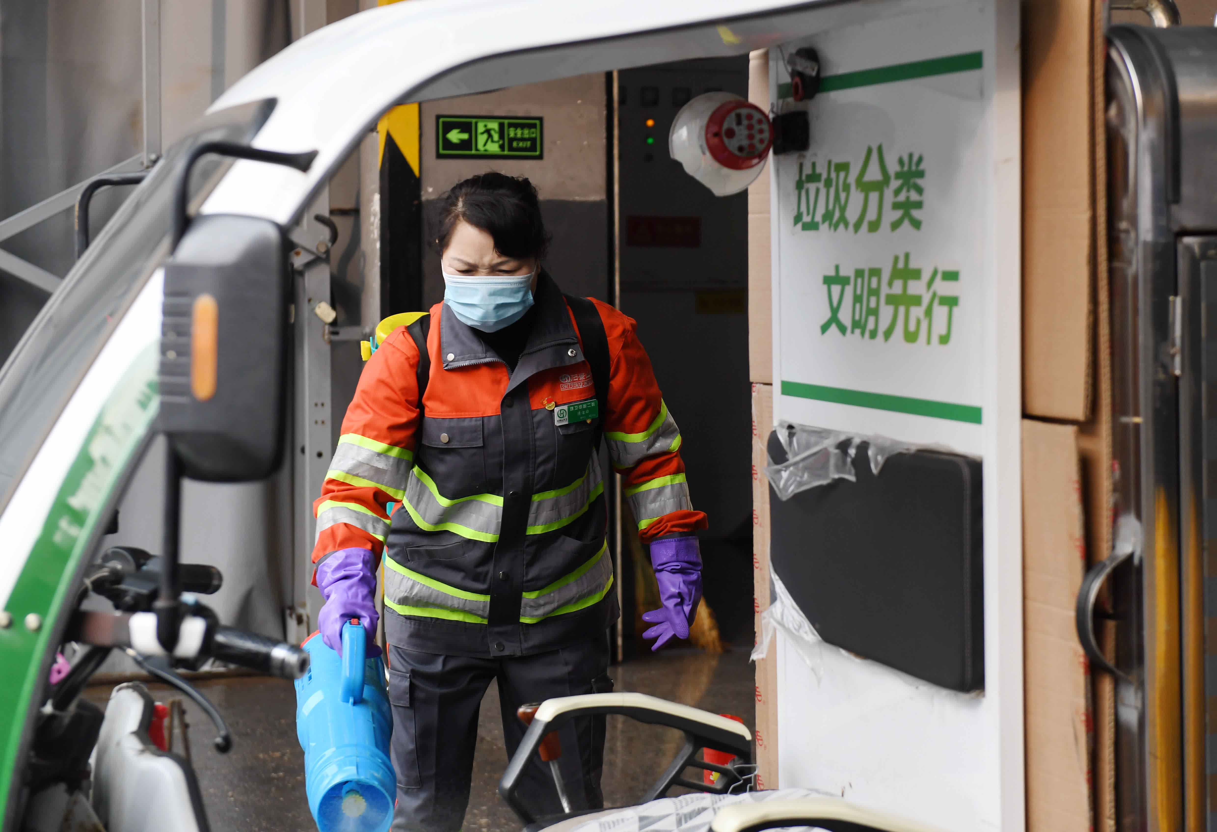 2月17日，劉明群給垃圾清潔站內正在傾倒垃圾的車輛消毒。（新華社）