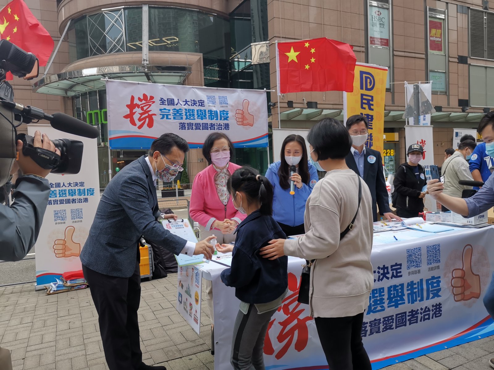 全國人大日前表決通過關於完善香港選舉制度的決定，得到香港社會各界同聲支持與擁護。連日來，多個愛國愛港團體在全港各區擺設街站，收集市民支持人大決定的簽名。政府官員亦親力親為。食衞局局長陳肇始，創新及科技局局長薛永恆局長，及立法會議員葛珮帆，港區全國人大代表陳勇亦在街頭，呼籲市民簽名，全力支持全國人大有關決定。（大公文匯全媒體記者攝）