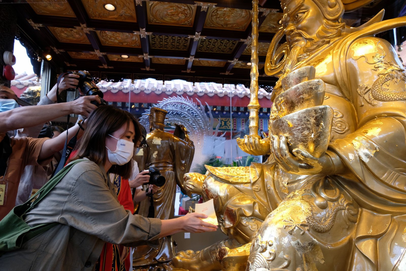 之後，將金箔貼在殿內神像上，注意不可貼在神像頭部。（大公文匯全媒體記者 麥鈞傑 攝）