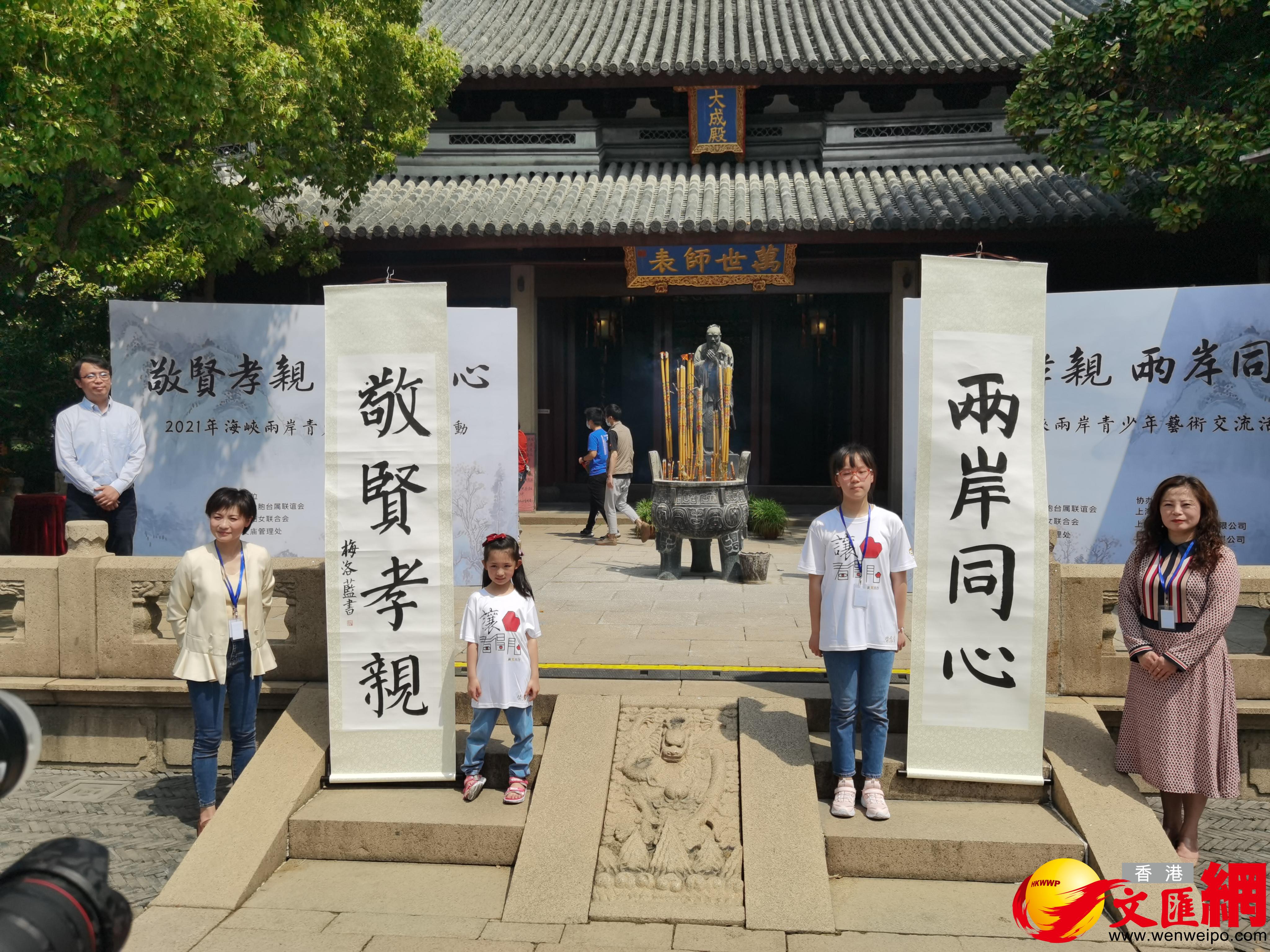 上海民辦永昌學校一年級的學生梅洛藍（左）和就讀於上海市竹園小學五年級的台灣學生韋宗彤，領銜書寫了本次活動主題「敬賢孝親、兩岸同心」。（香港文匯網記者張帆 攝）