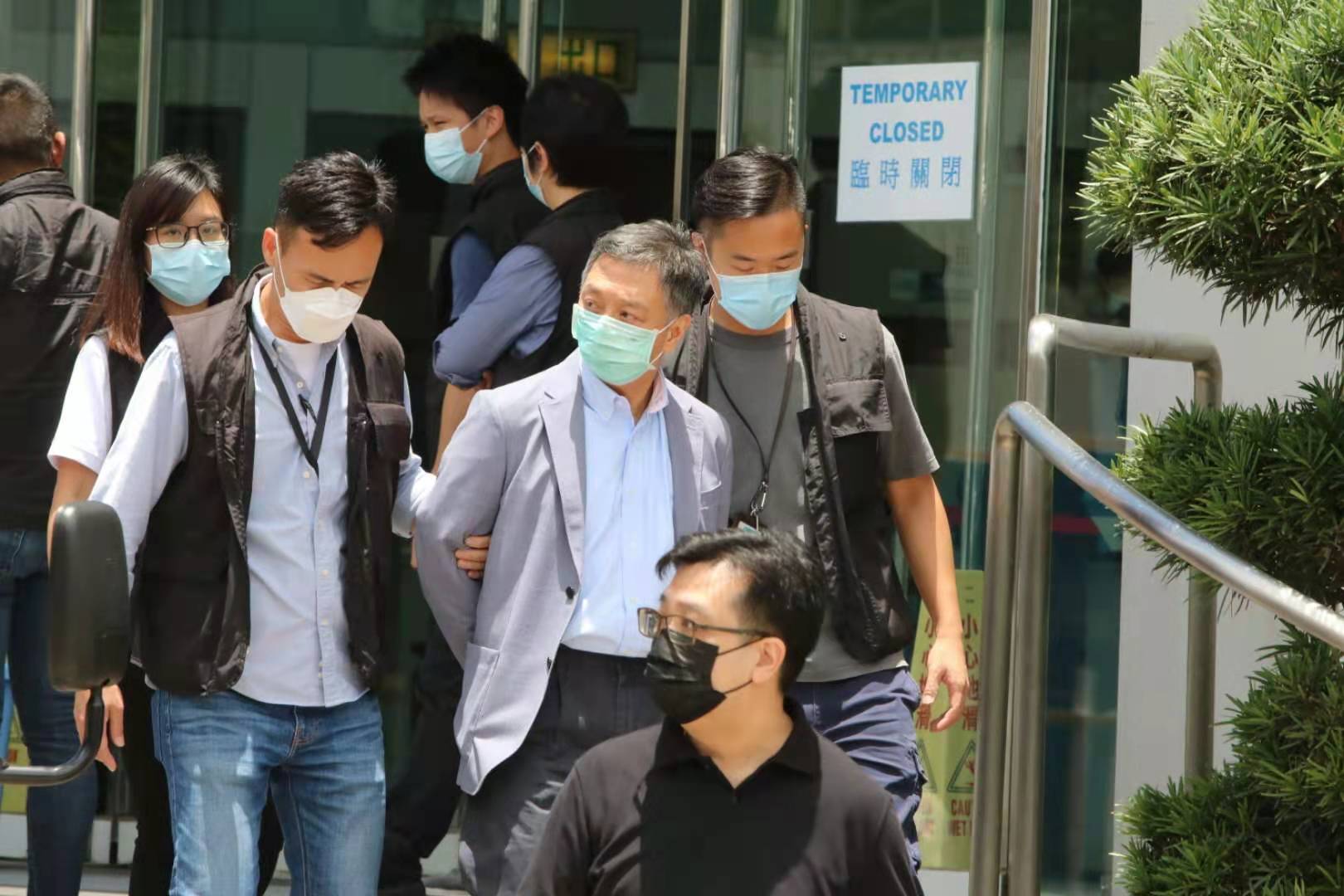 壹傳媒營運總裁周達權被押送離開大樓。(香港文匯報記者攝) 壹傳媒營運總裁周達權被押送離開大樓。(香港文匯報記者攝)