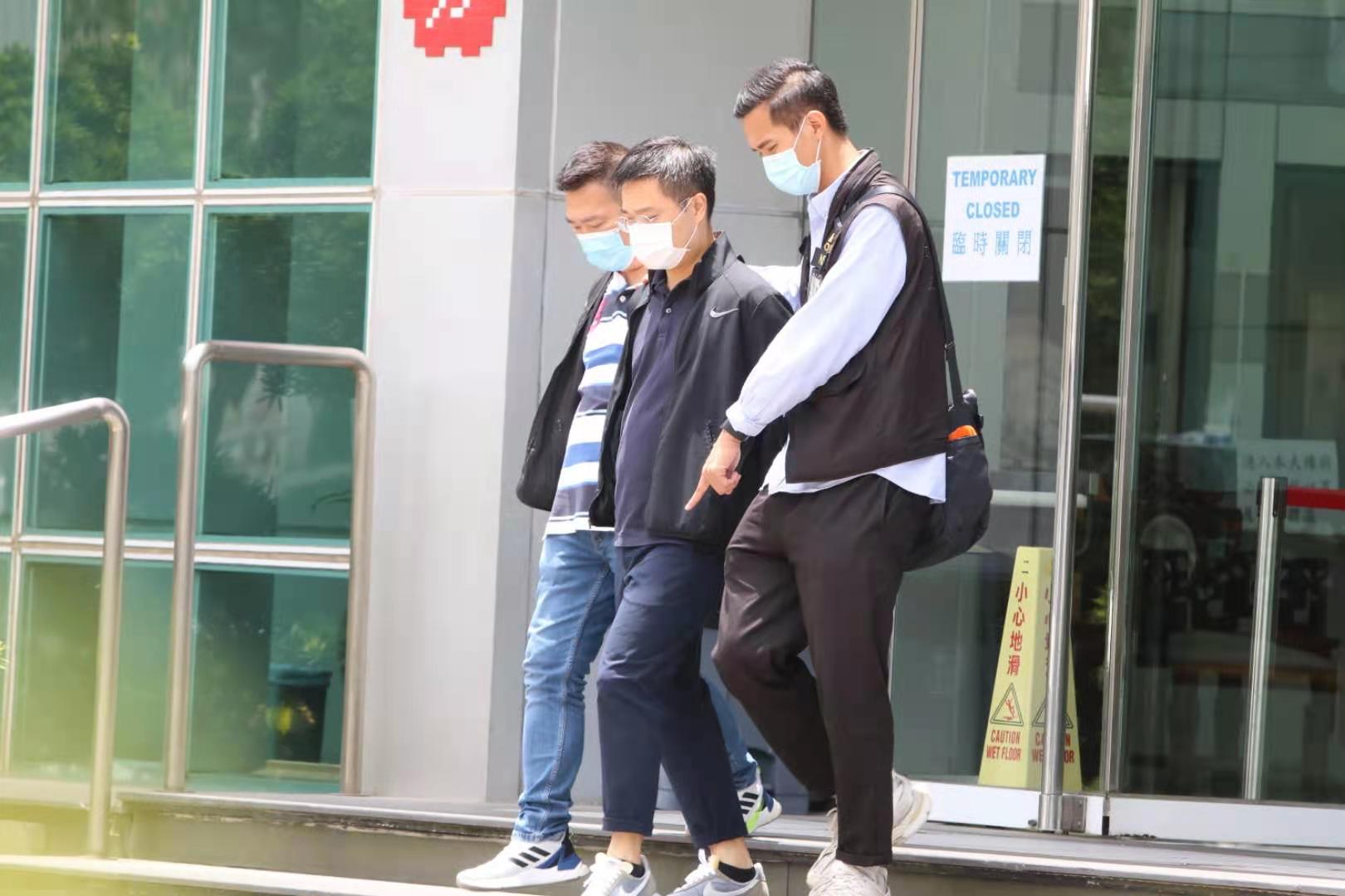 《蘋果日報》總編輯羅偉光在警員押送下離開大樓。(香港文匯報記者攝) 《蘋果日報》總編輯羅偉光在警員押送下離開大樓。(香港文匯報記者攝)