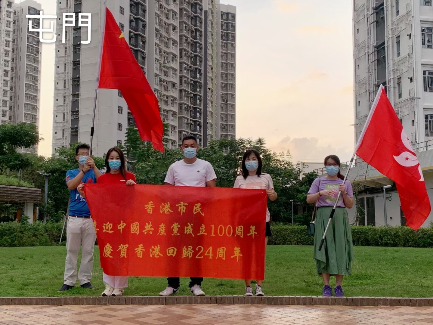 屯門有市民高舉國旗區旗及拉起橫額，慶祝建黨100周年及香港回歸24周年。（市民供圖）