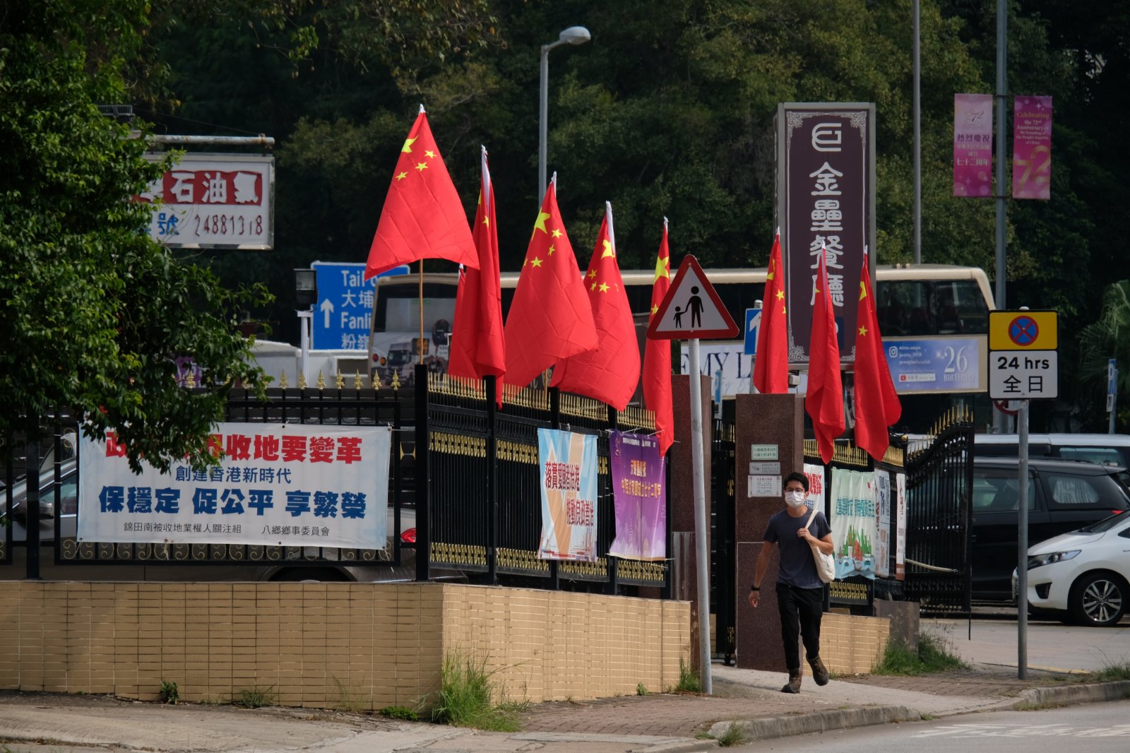 市民路過一排火紅的國旗。（大公文匯全媒體記者 麥鈞傑 攝）