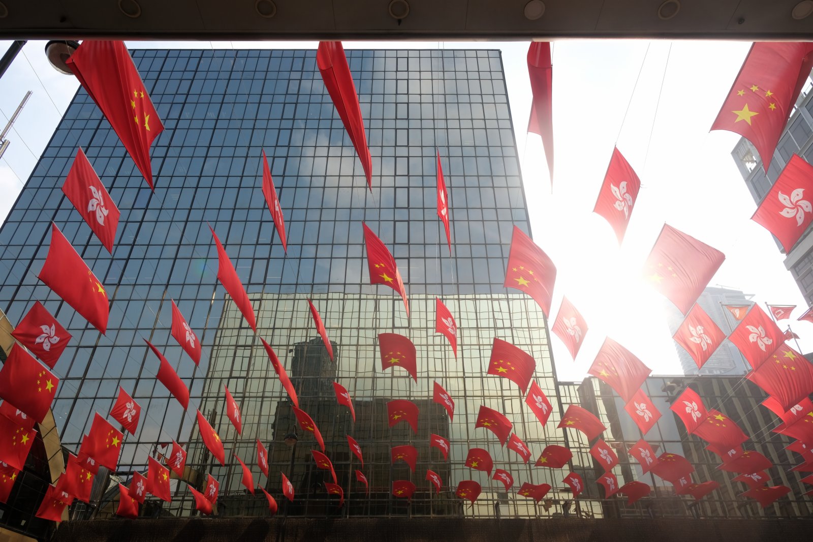 市民路過一排火紅的國旗和區旗。（大公文匯全媒體記者 麥鈞傑 攝）