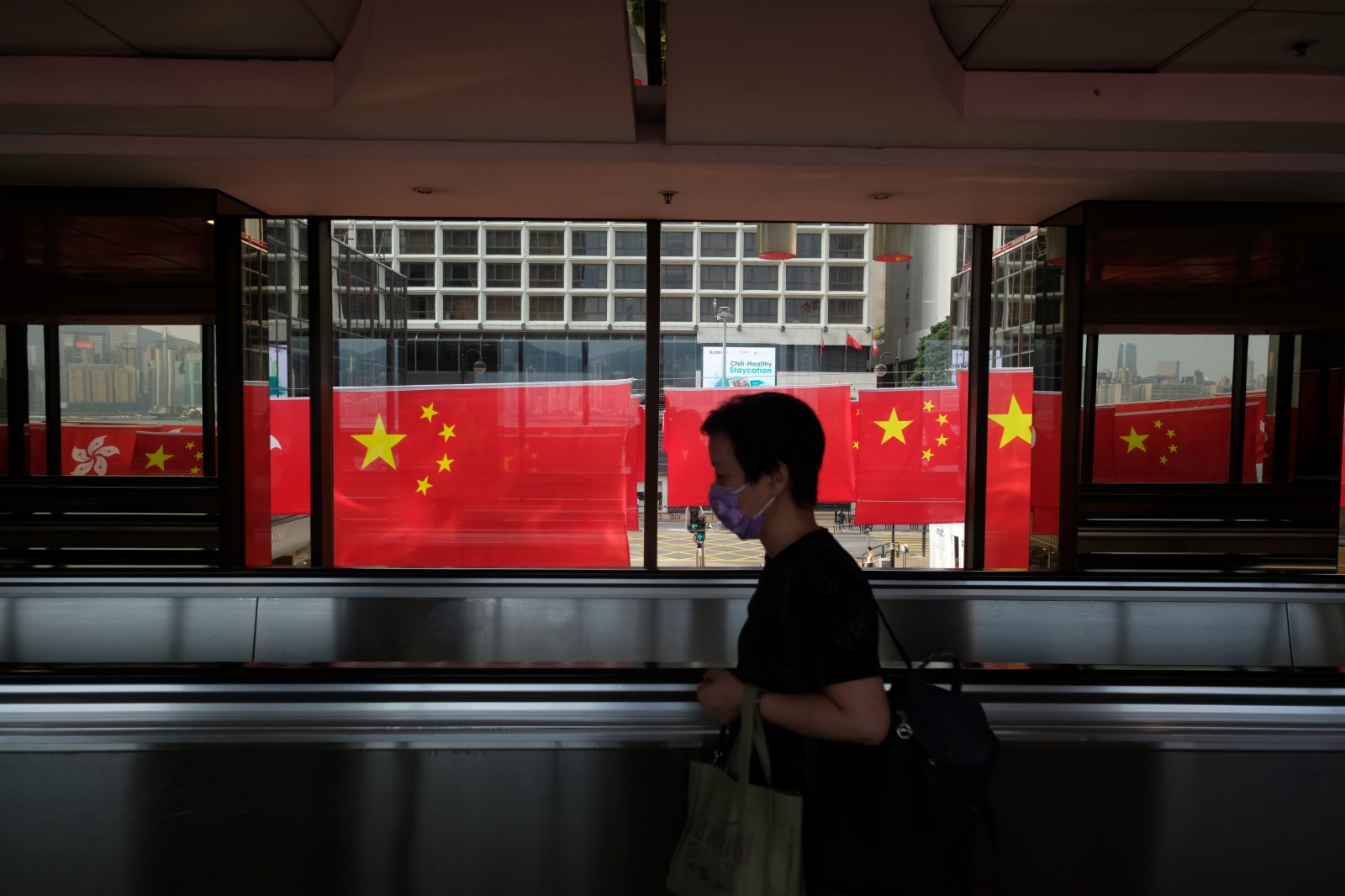 市民路過一排火紅的國旗和區旗。（大公文匯全媒體記者 麥鈞傑 攝）