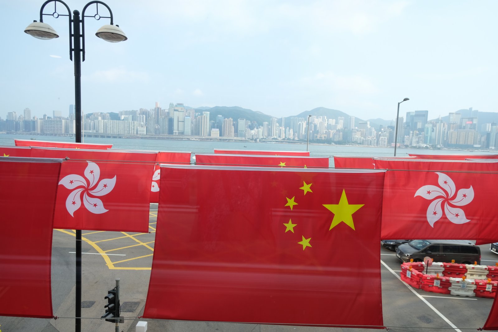 市民路過一排火紅的國旗和區旗。（大公文匯全媒體記者 麥鈞傑 攝）