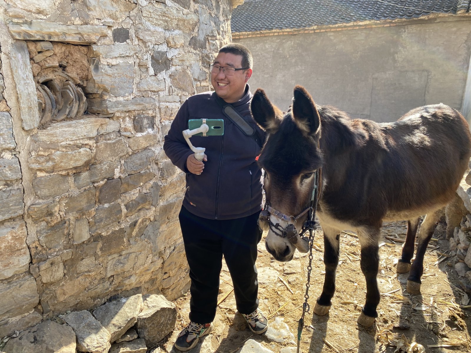 胖驢兒(王虎林)拍短視頻介紹合作社小米(記者顧大鵬攝)