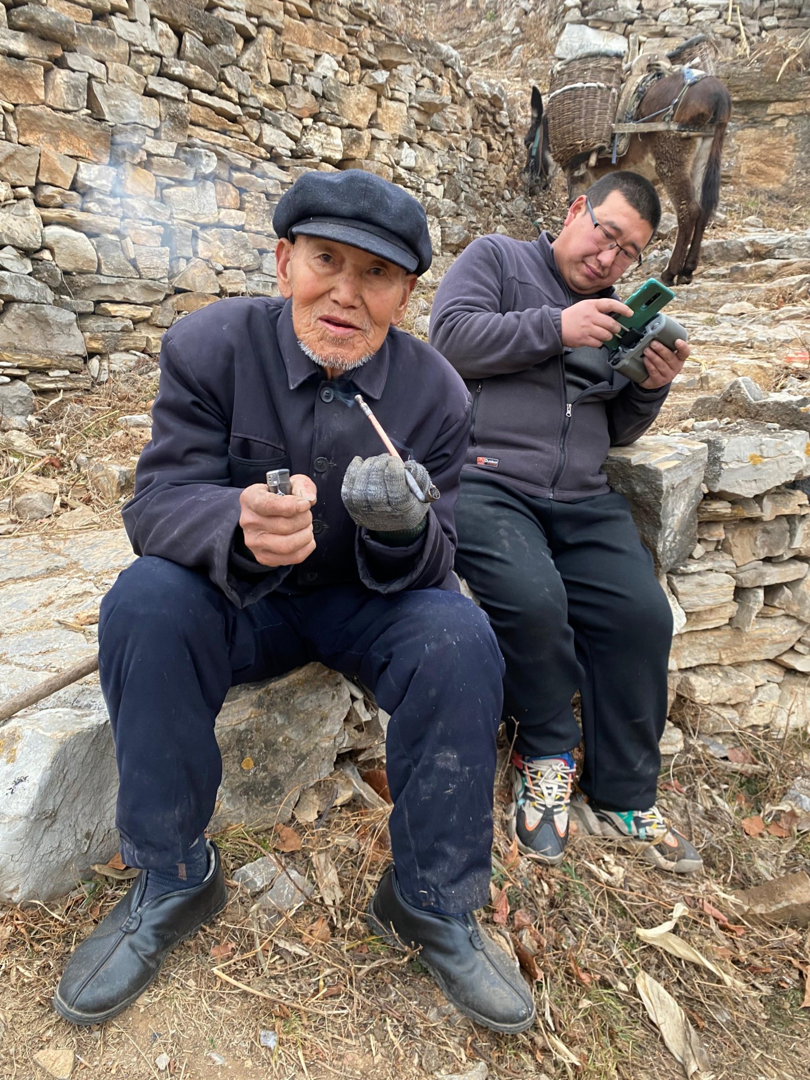 爺爺在地頭抽煙，孫子手頭也不閒着（記者顧大鵬攝）