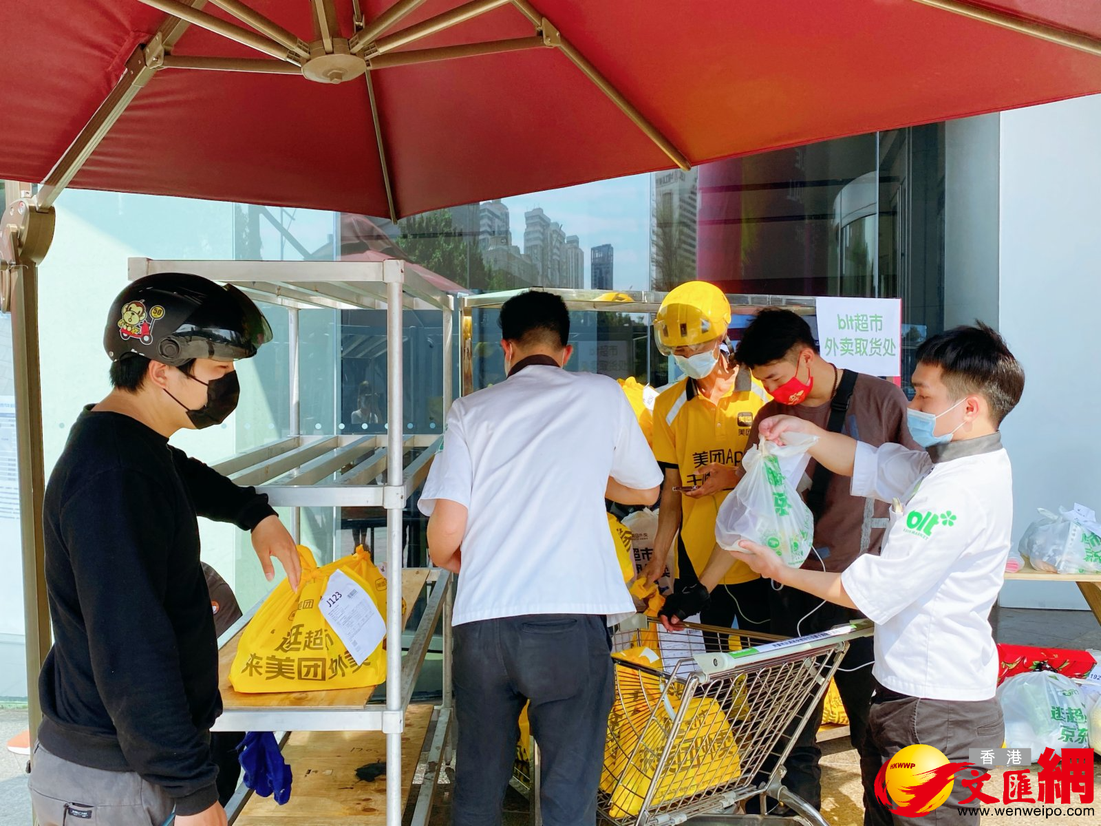 外賣小哥和超市工作人員在戶外交接外賣。 外賣小哥和超市工作人員在戶外交接外賣。