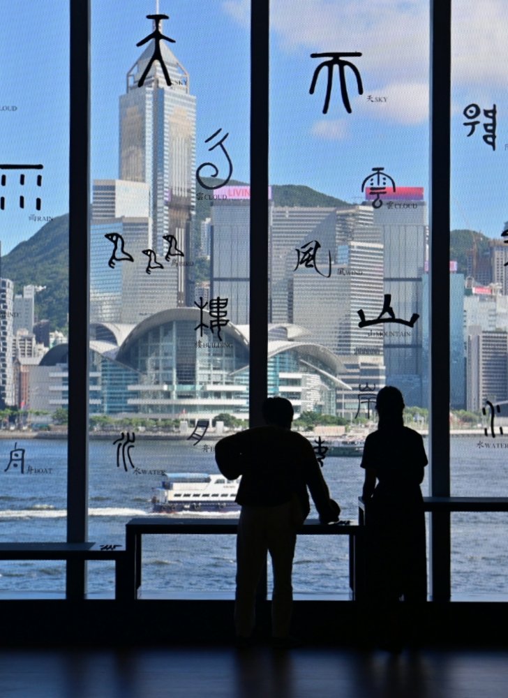 展廳外玻璃窗貼上不同書體的漢字，把維港景色化身成文字的風景。（政府新聞處）