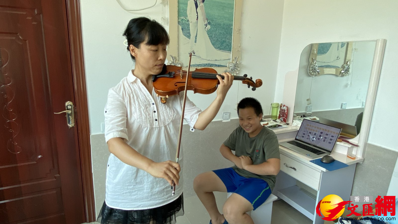 北京某大學教師和兒子來到溫芳家，體驗農村生活，圖為武老師在農家給兒子做音樂示範。（香港文匯網記者顧大鵬 攝）