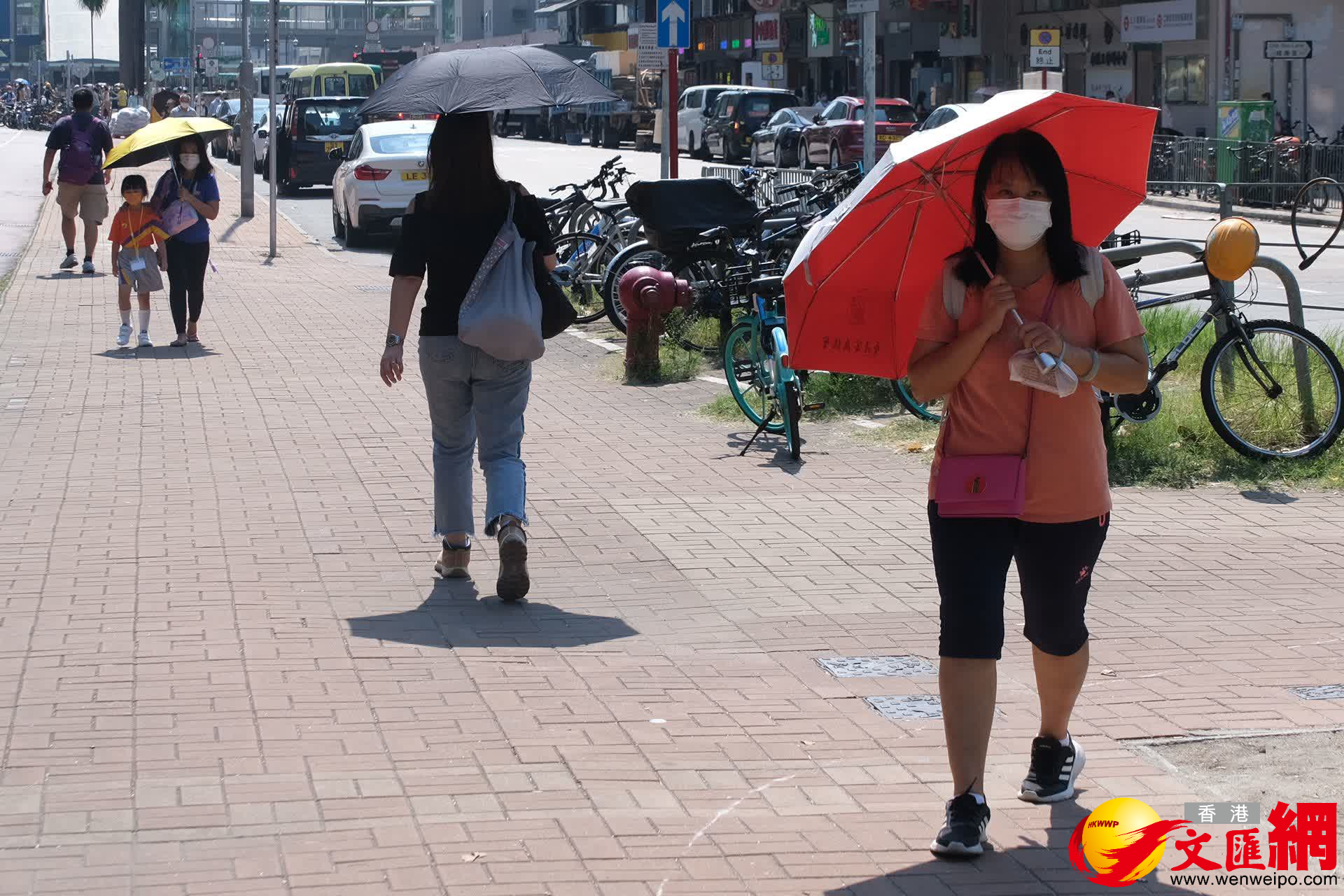 有市民出街選擇撐傘，防止中暑。（大公文匯全媒體記者 麥鈞傑 攝）