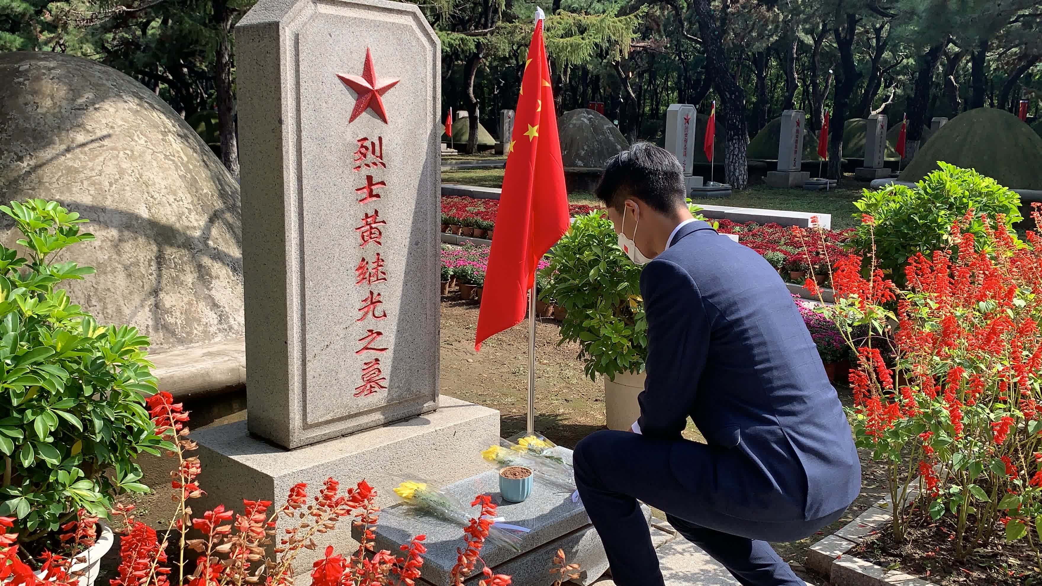 姜霏梵向烈士墓碑敬獻代表哀思的黃色菊花。 姜霏梵向烈士墓碑敬獻代表哀思的黃色菊花。