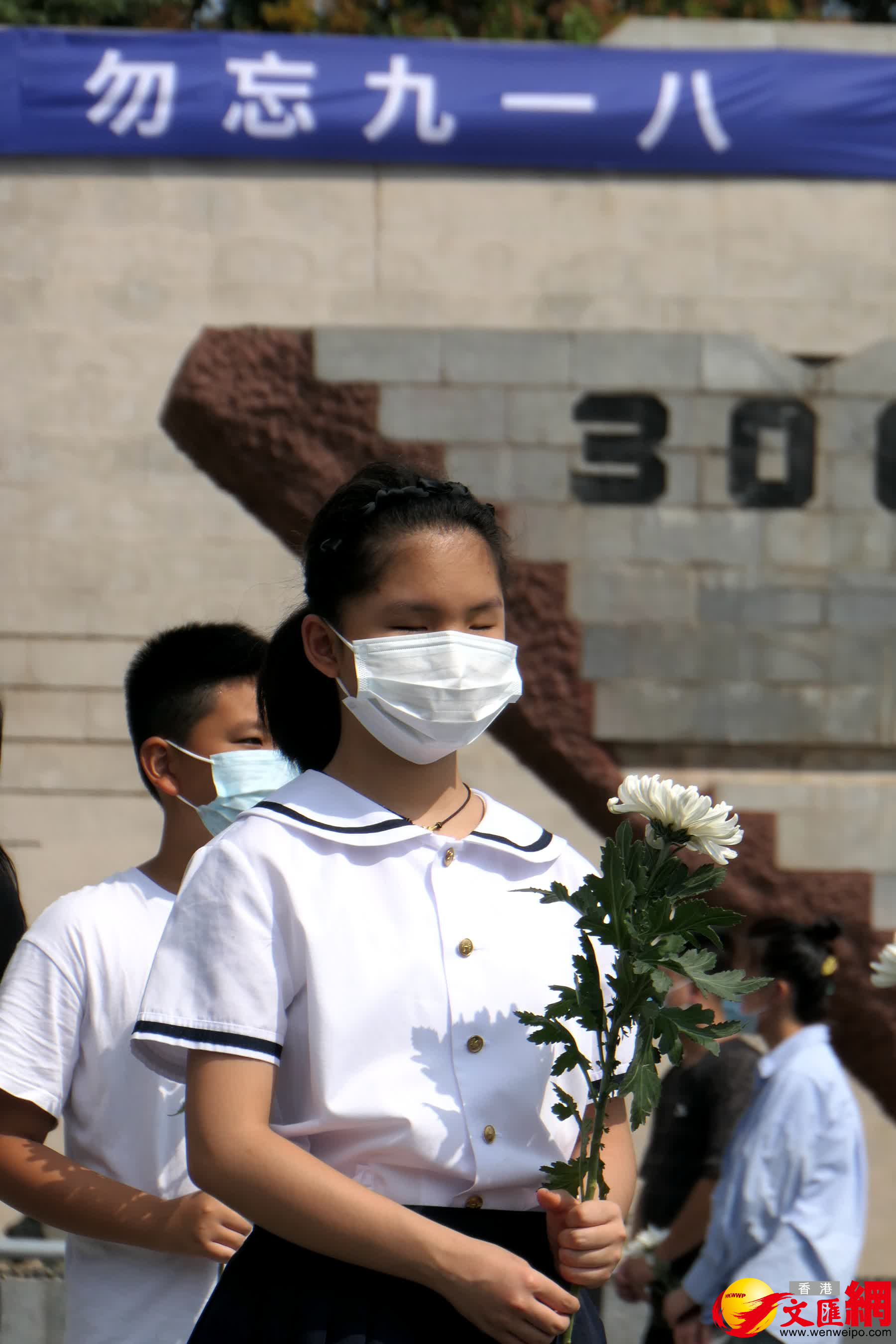 圖為一位盲童在家人帶領下參觀紀念館，並向遇難同胞默哀。（賀鵬飛攝）