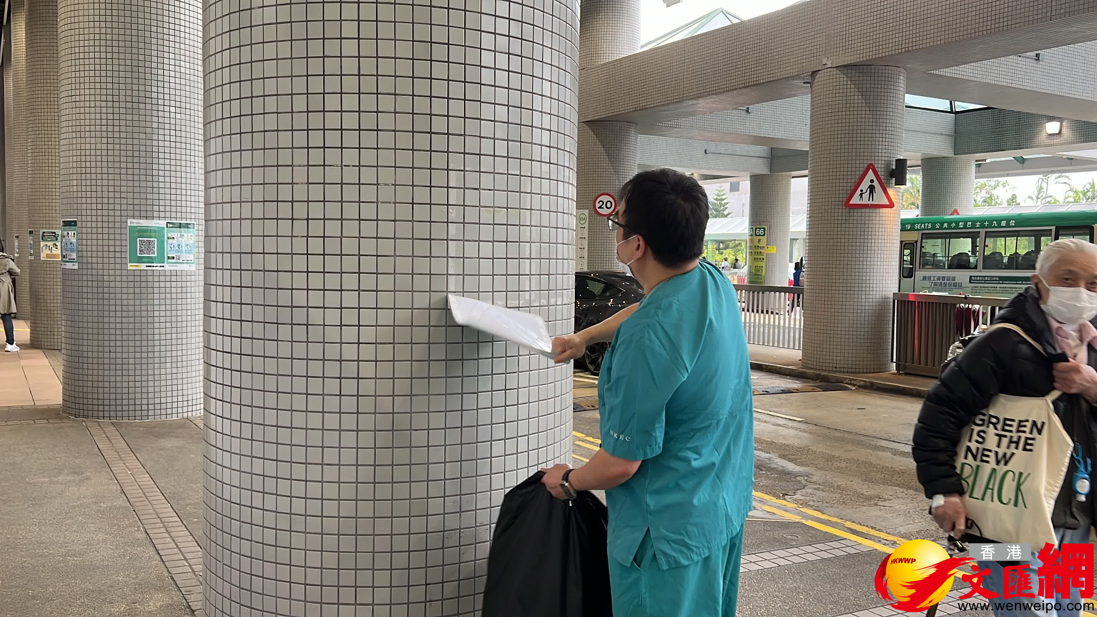 工作人員正在取下部分貼在醫院大樓外的「安心出行」二維碼。（大公文匯全媒體記者 蘇婷 攝）