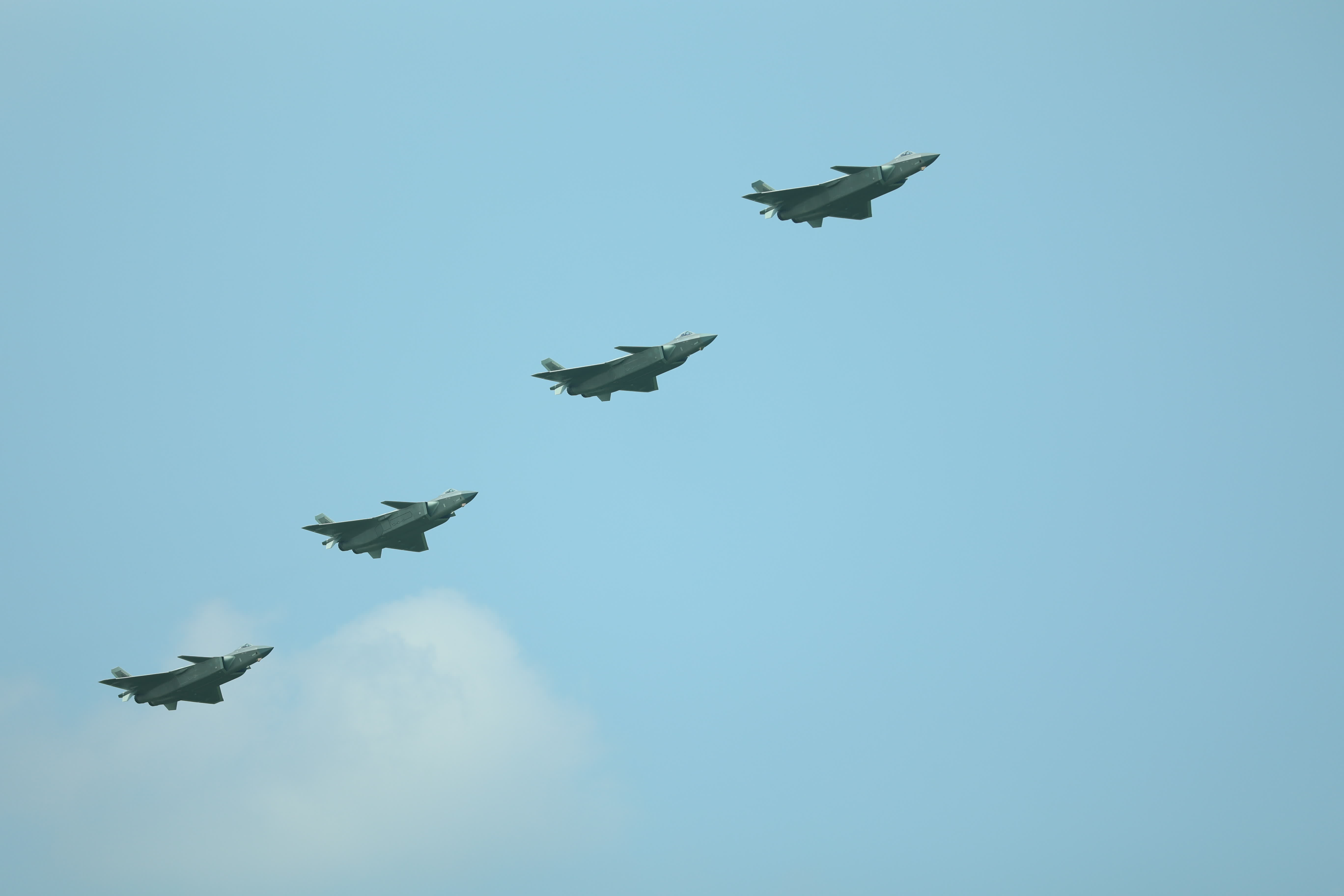 4架殲-20戰機以尾後隊形密集編隊低空通場（盧冶攝）