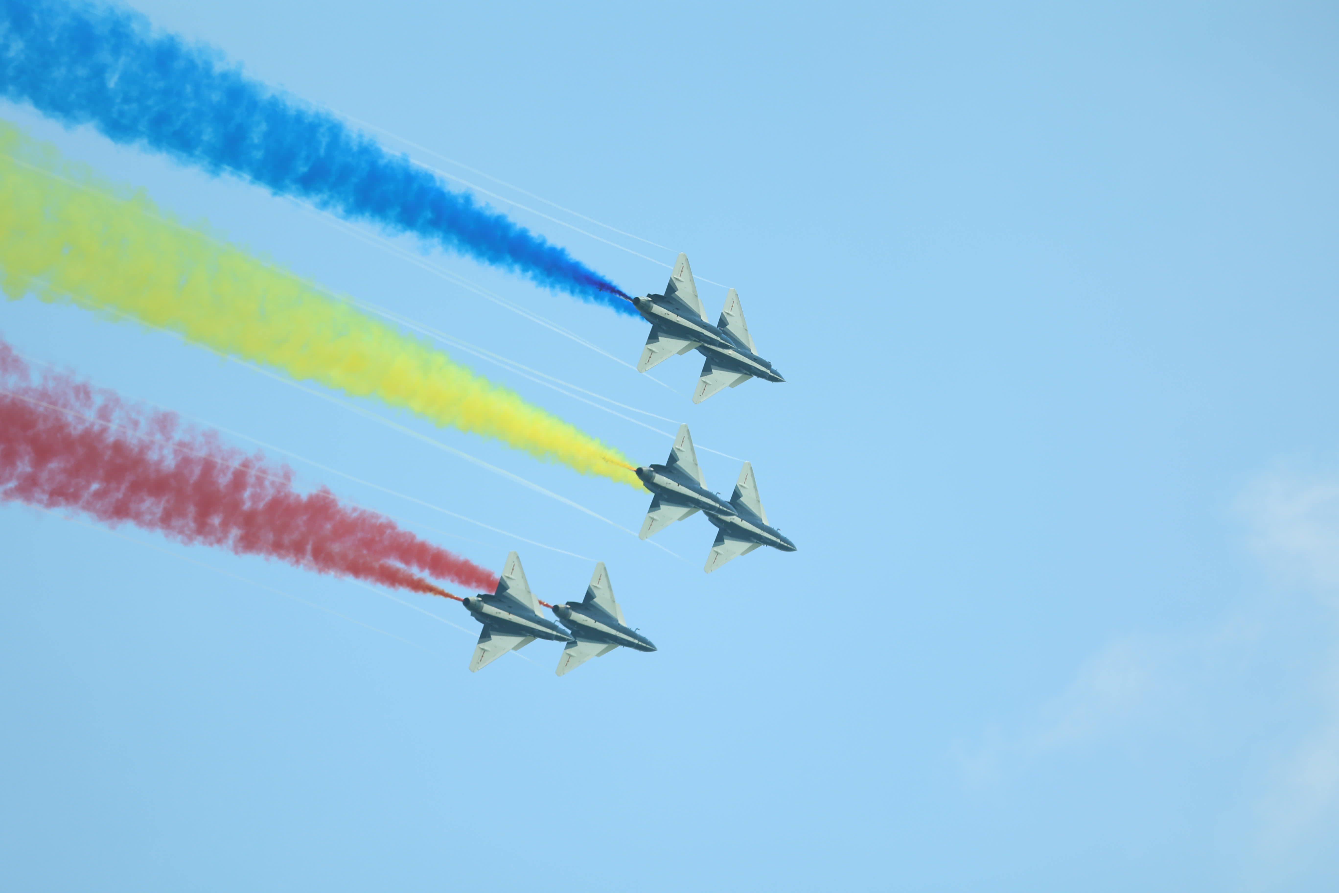 八一飛行表演隊雙三角隊正朝觀眾席飛來，鮮艷的水彩傾瀉而下。（盧冶攝）