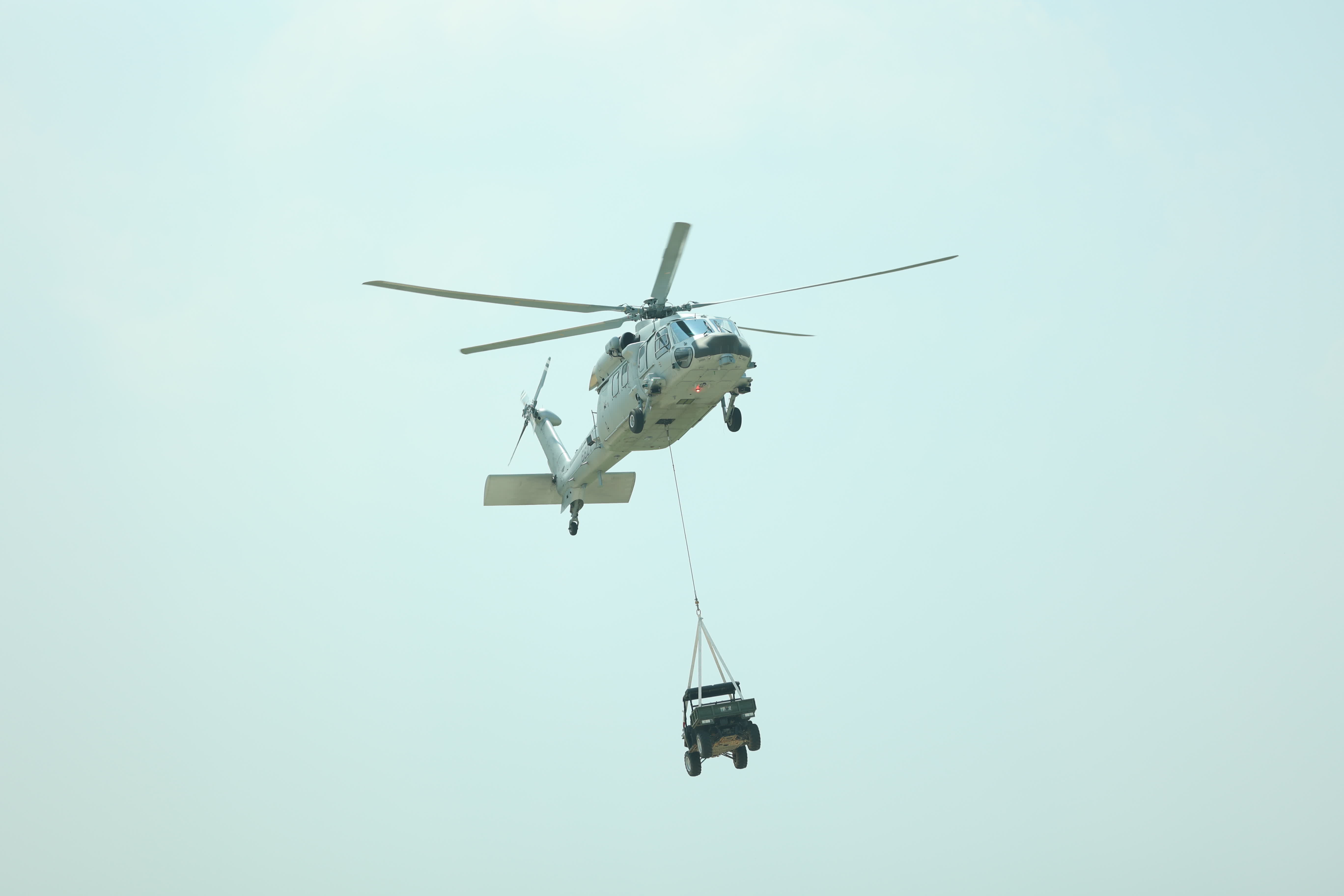 直升機吊掛一輛4×4全地形車前來協助突擊隊員撤離。（盧冶攝）