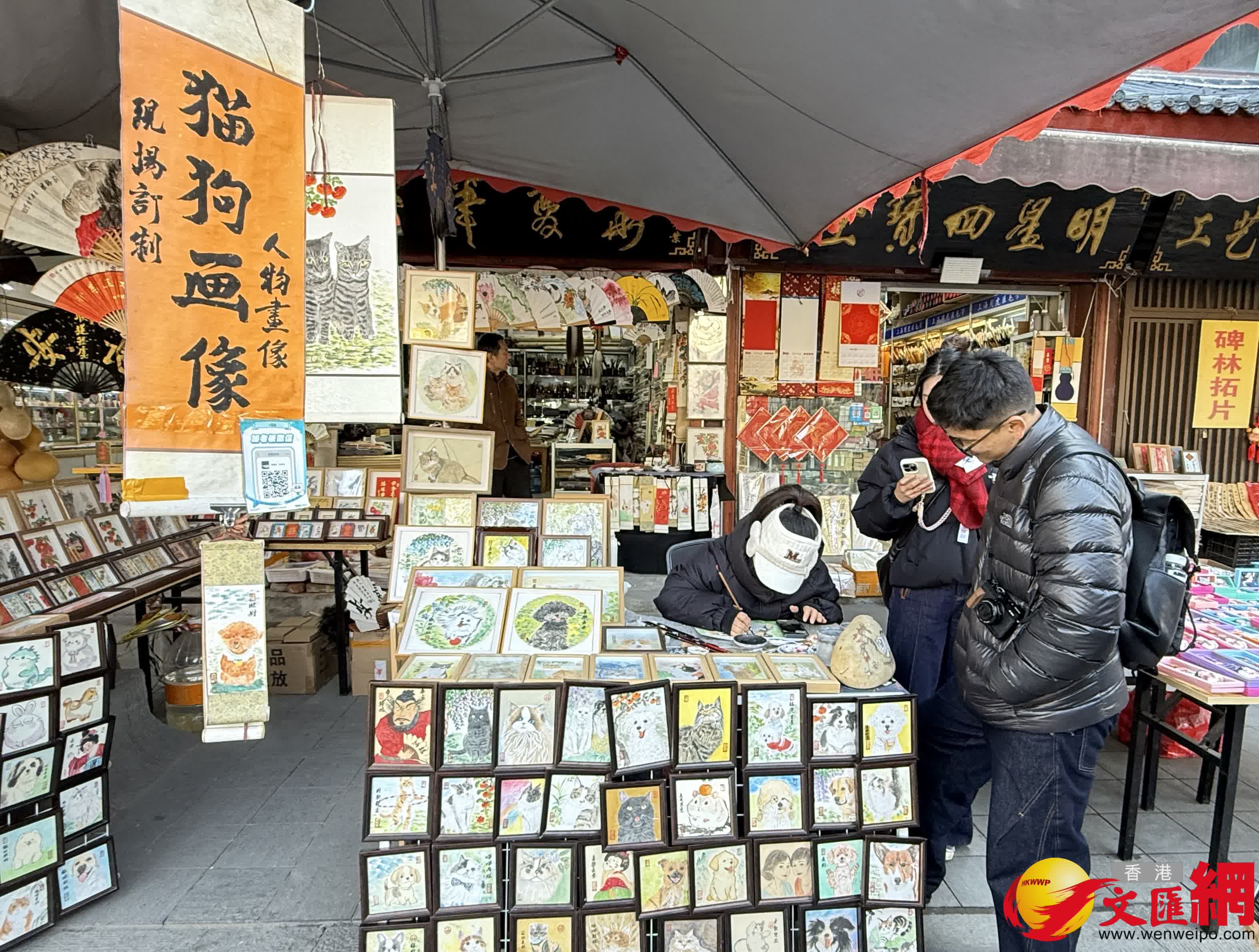 西安書院門巷陌間墨香四溢，書畫攤位沿街舖開，筆墨紙硯整齊陳列。（記者張仕珍 攝）