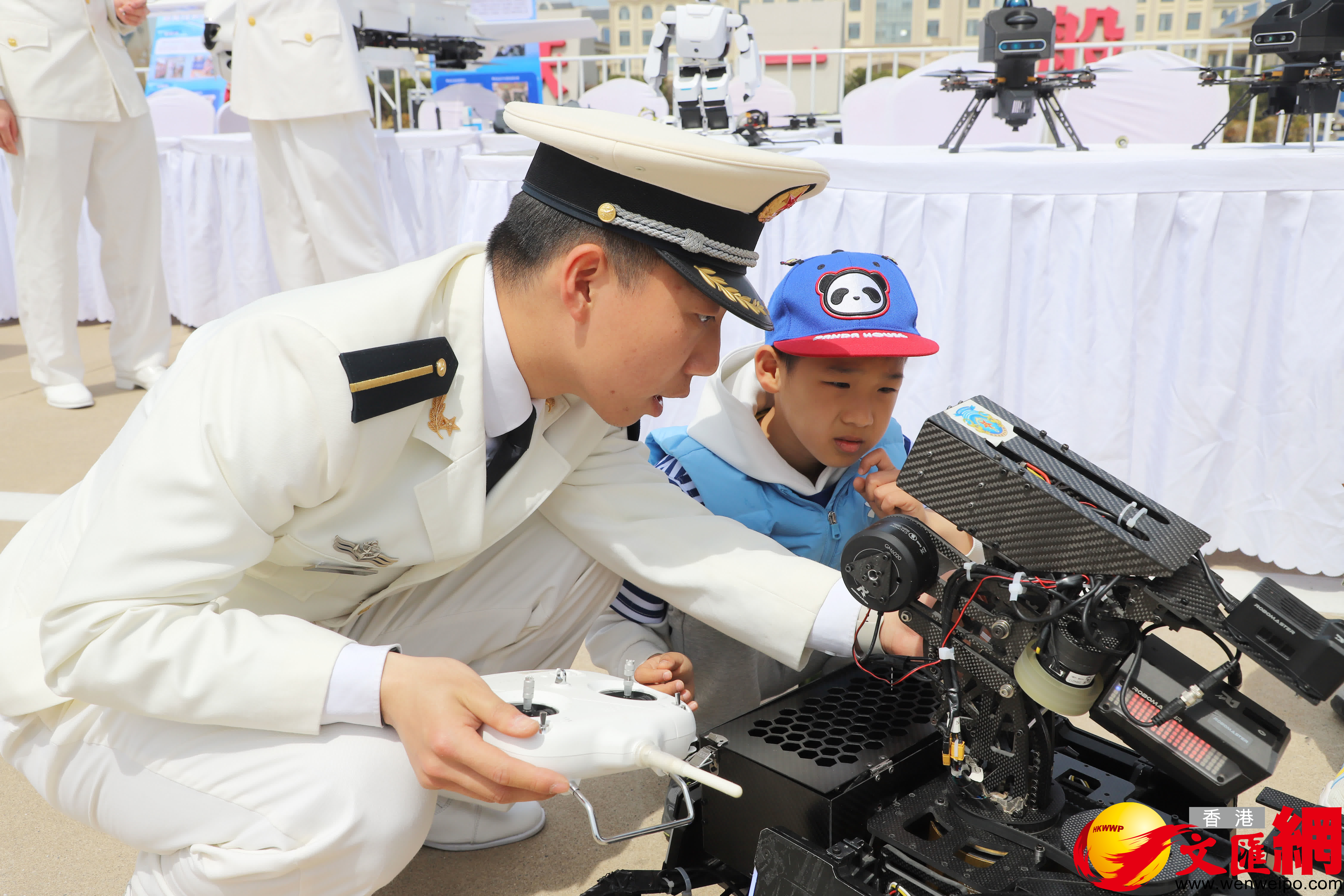 海軍大連艦艇學院學員和小觀眾互動。（記者宋偉攝）