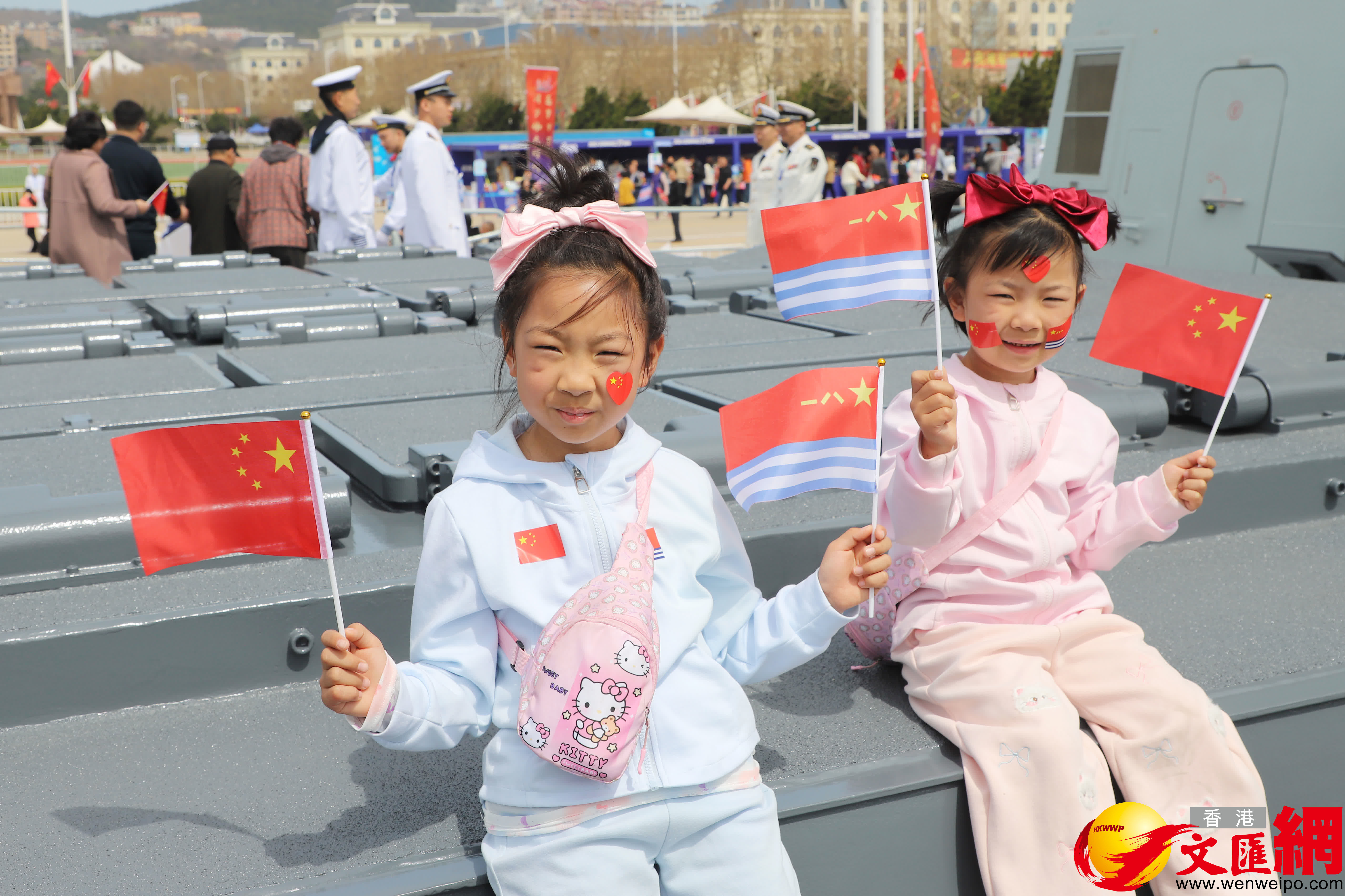 小觀眾坐在鄂爾多斯艦導彈垂發裝置旁歡慶海軍節。（記者宋偉攝）