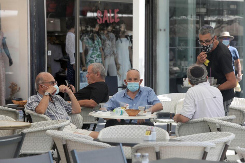 這是9月14日在以色列城市內坦亞街頭拍攝的戴口罩的民眾。 以色列衞生部14日公布的數據顯示，當天該國新增確診病例4764例，創疫情暴發以來單日新增病例數新高，累計確診160368例。
