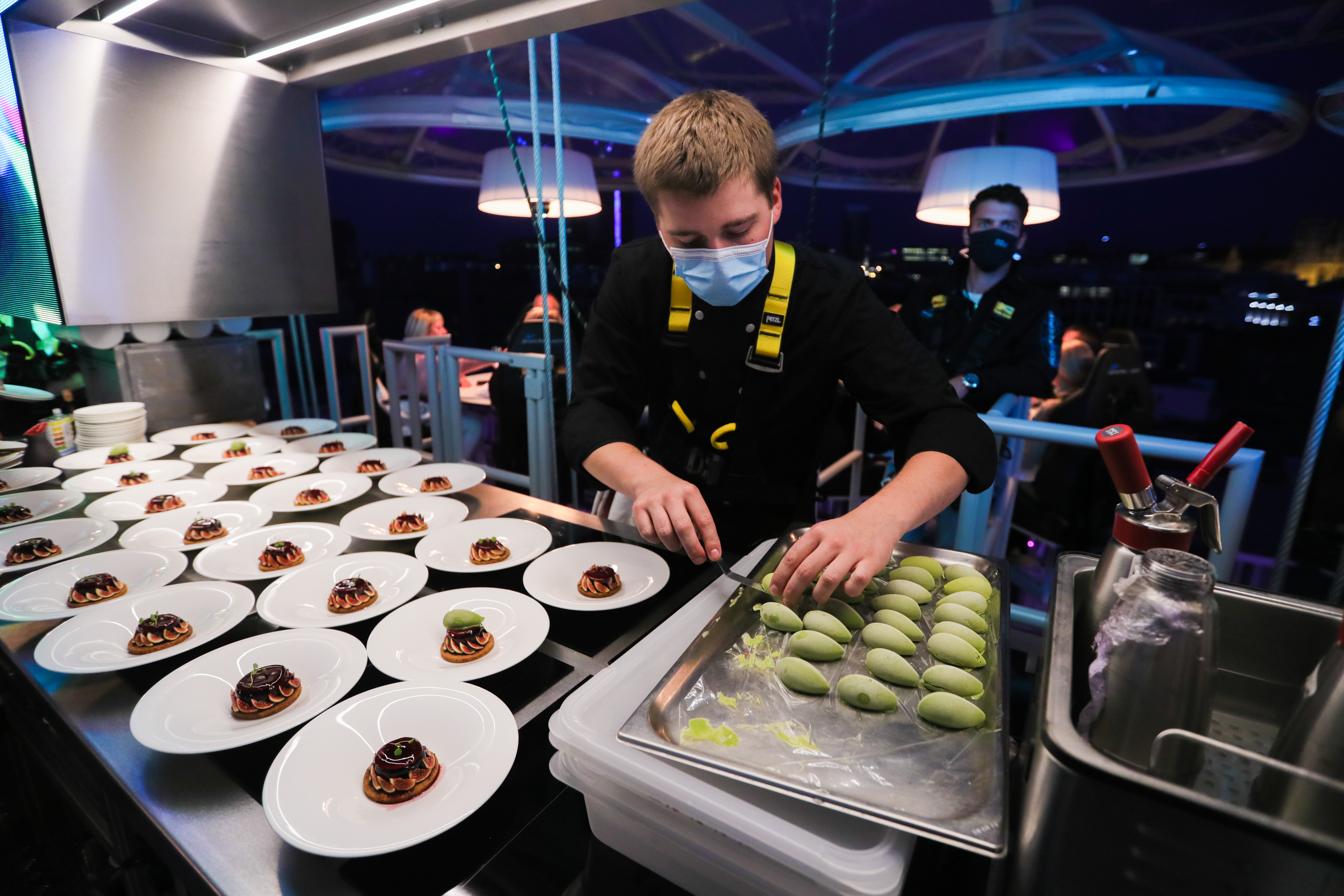 9月18日，工作人員在比利時首都布魯塞爾的「空中餐廳」為食客準備美食。 近日，「空中餐廳」在比利時首都布魯塞爾市中心營業。 「空中餐廳」概念於2006年起源於比利時，迄今已在許多國家和地區鋪設過餐桌。今年的布魯塞爾「空中餐廳」最高可升至約50米，設有8個獨立餐桌，可在遵守「社交距離」的規則下容納32名食客，每人就餐需要花費295歐元（約合2369元人民幣）。 （新華社記者 鄭煥松 攝）