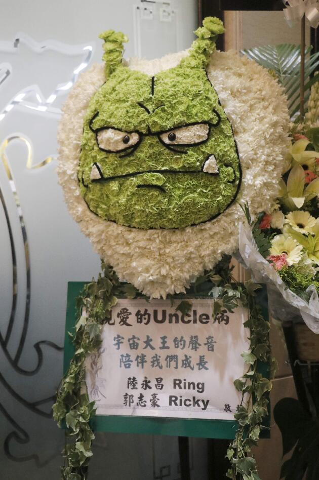 有兩位稱譚炳文為Uncle的後輩，贈送的花牌上有「宇宙大王」公仔。（大公文匯全媒體記者攝）
