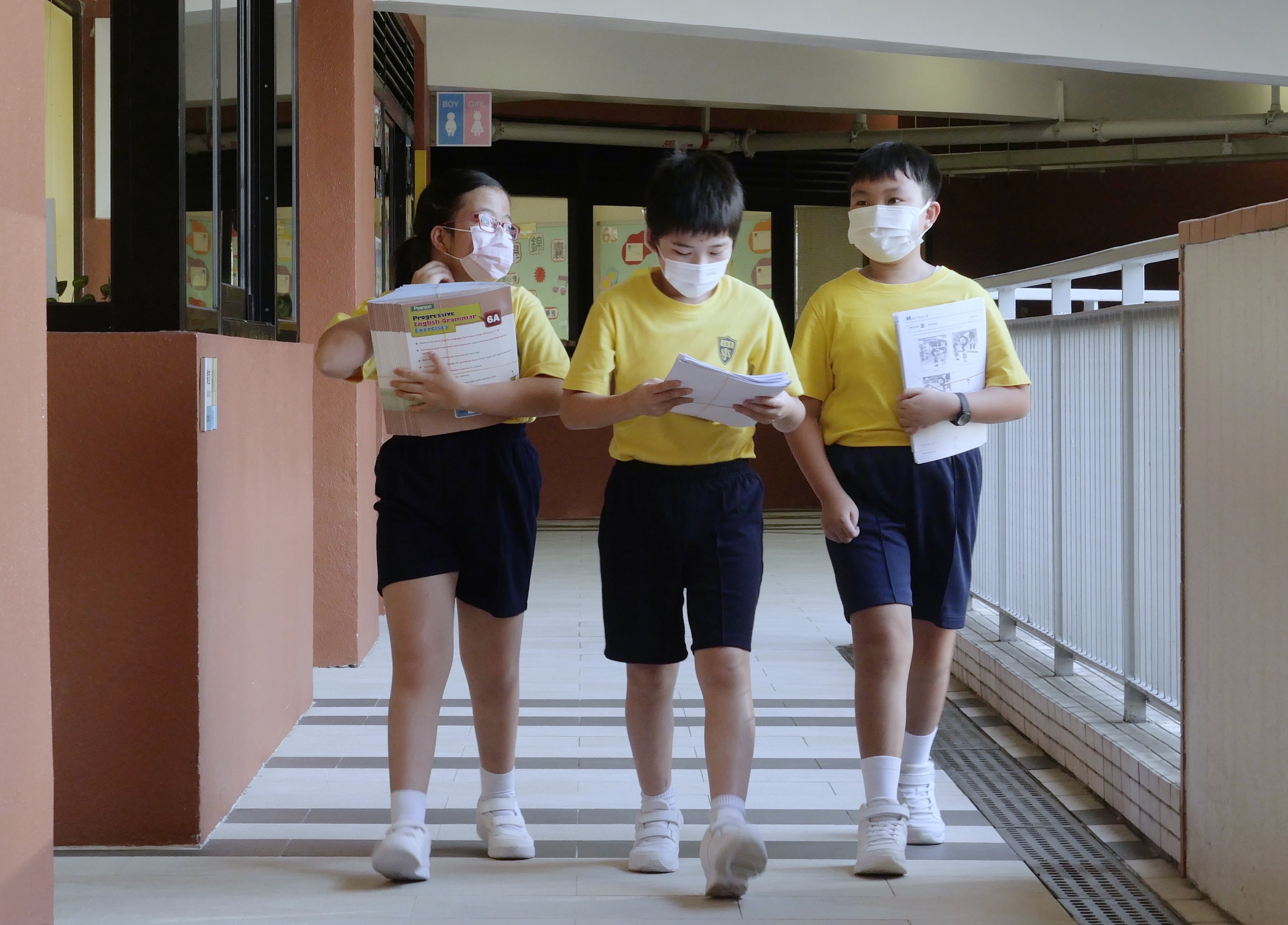 9月23日，在位於香港灣仔的聖公會聖雅各小學，小學生抱著書本走在校園中。（ 新華社記者 王申 攝）