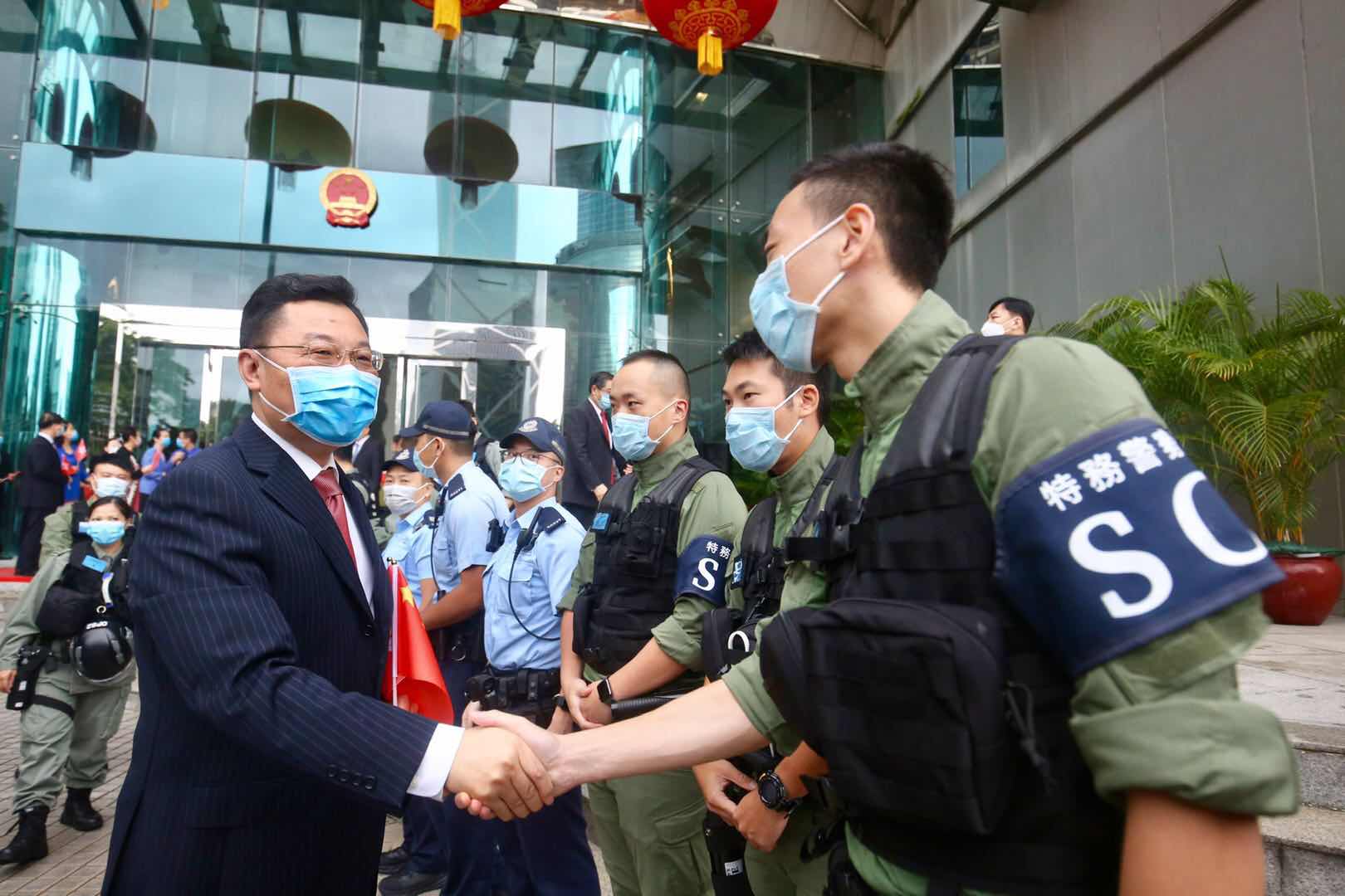 10月1日早晨，中央駐港國安公署與外交部駐港特派員公署舉行升旗儀式。圖為：謝鋒特派員問候並與警員握手（大公文匯全媒體 記者 攝）