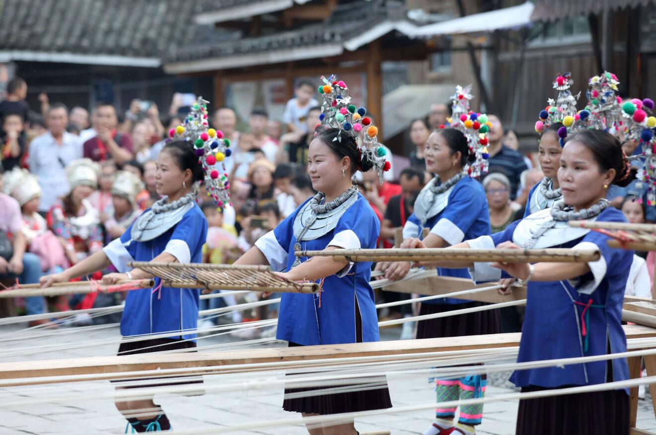 10月2日，侗族群眾在三江侗族自治縣林溪鎮程陽八寨景區表演侗族紡紗。（新華社）