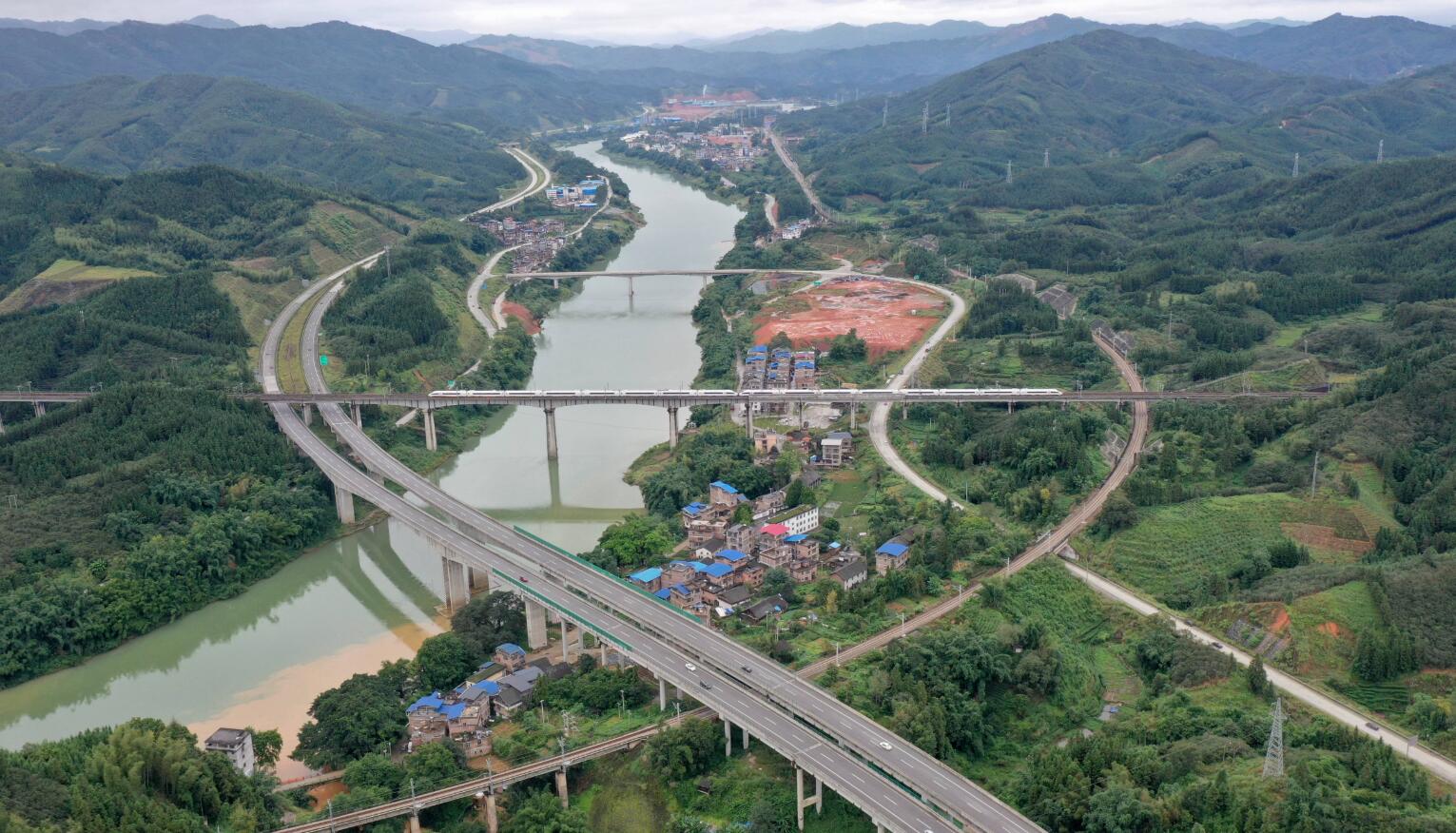 10月4日，一列動車行經貴廣高鐵三江侗族自治縣程村鄉泗裡村路段（無人機照片）。（新華社）