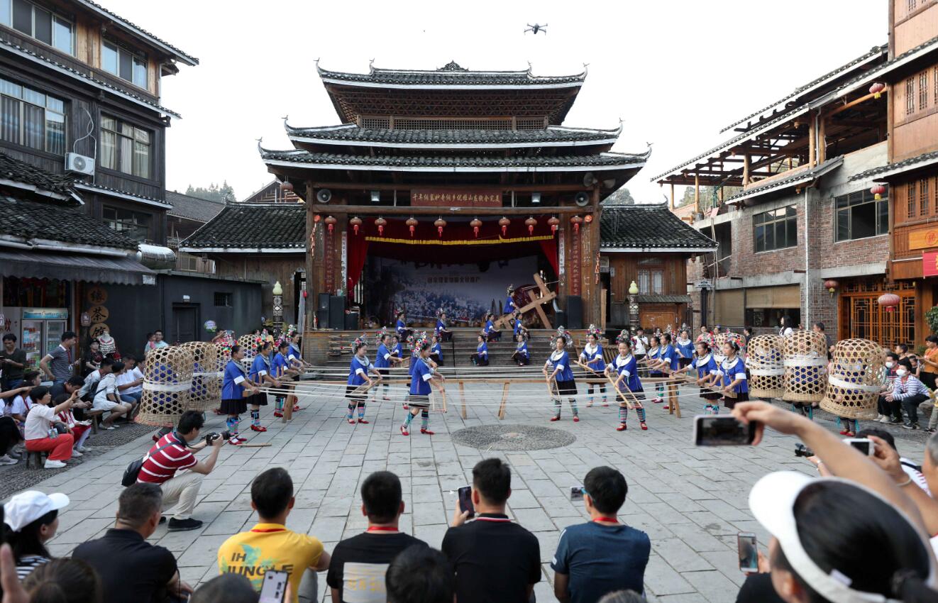 10月2日，遊客在三江侗族自治縣林溪鎮程陽八寨景區觀看侗族紡紗表演。（新華社）