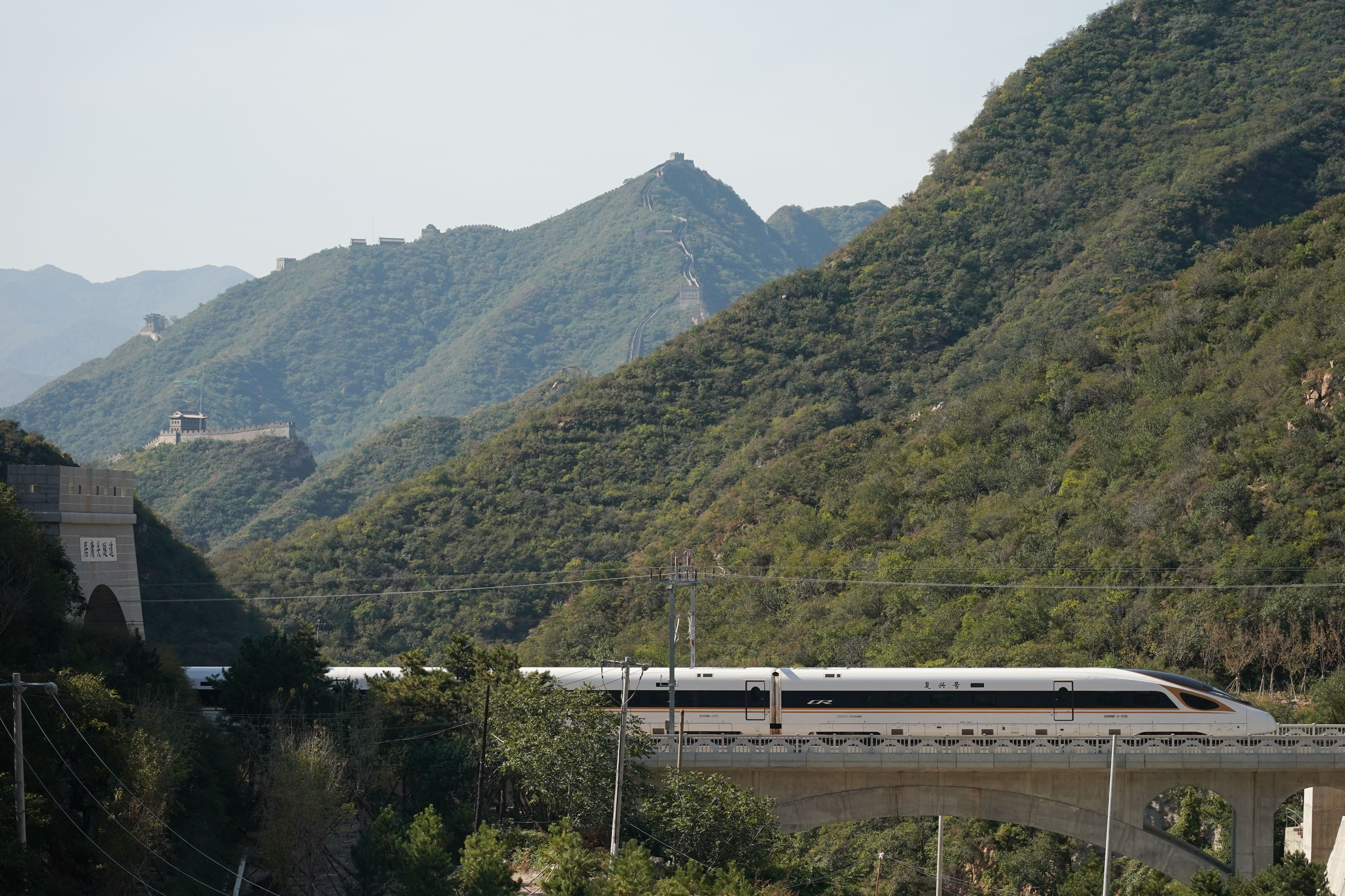 一列復興號高鐵列車從京張高鐵駛過居庸關長城(10月6日攝)。 (新華社)