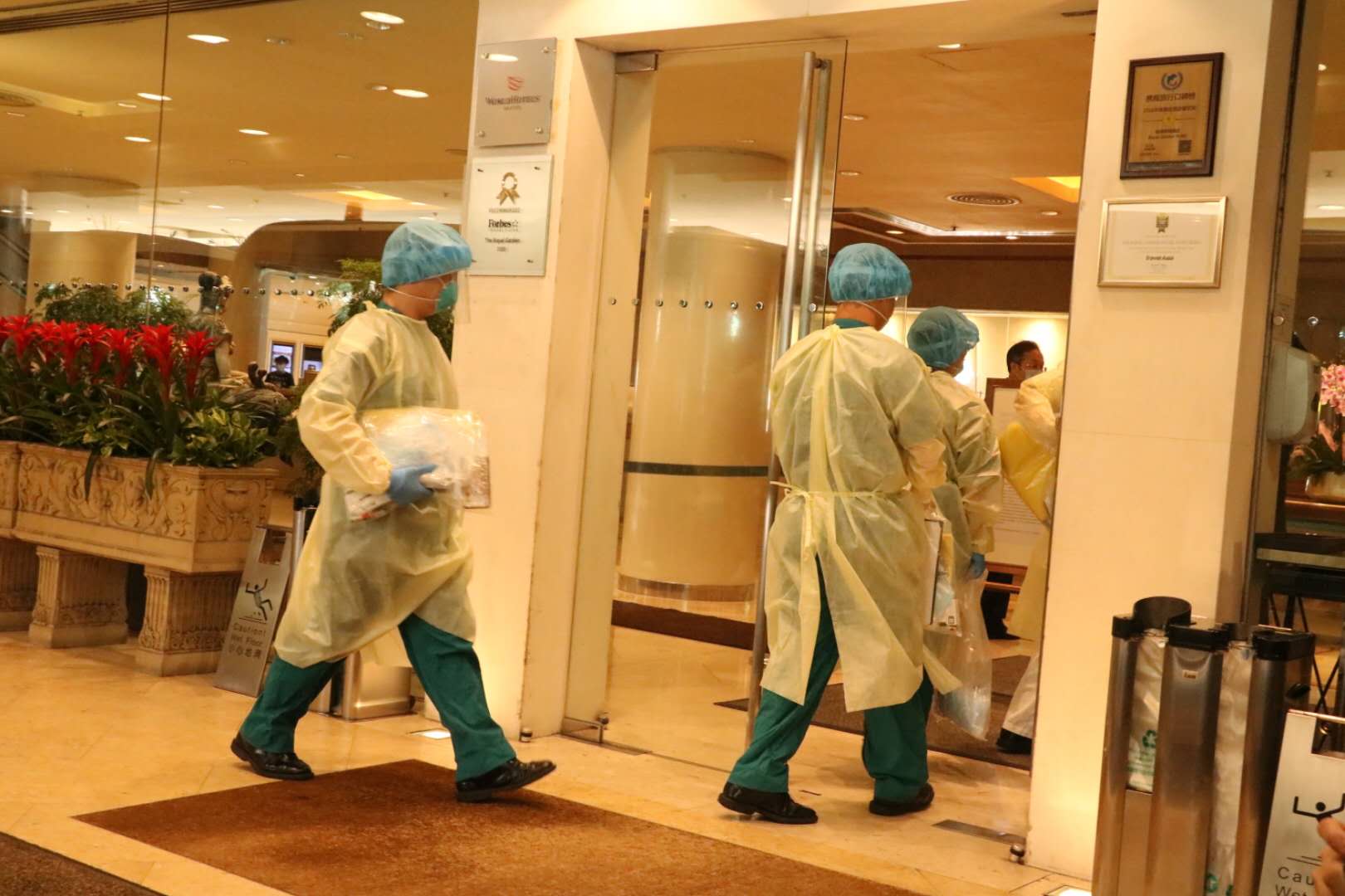 穿上全副保護衣的人員進入帝苑酒店。(大公文匯全媒體記者 攝)