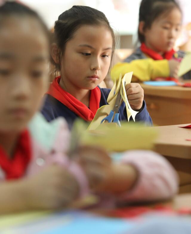 10月9日，蘇州工業園區星海小學的學生在體驗剪紙技藝。（新華社）