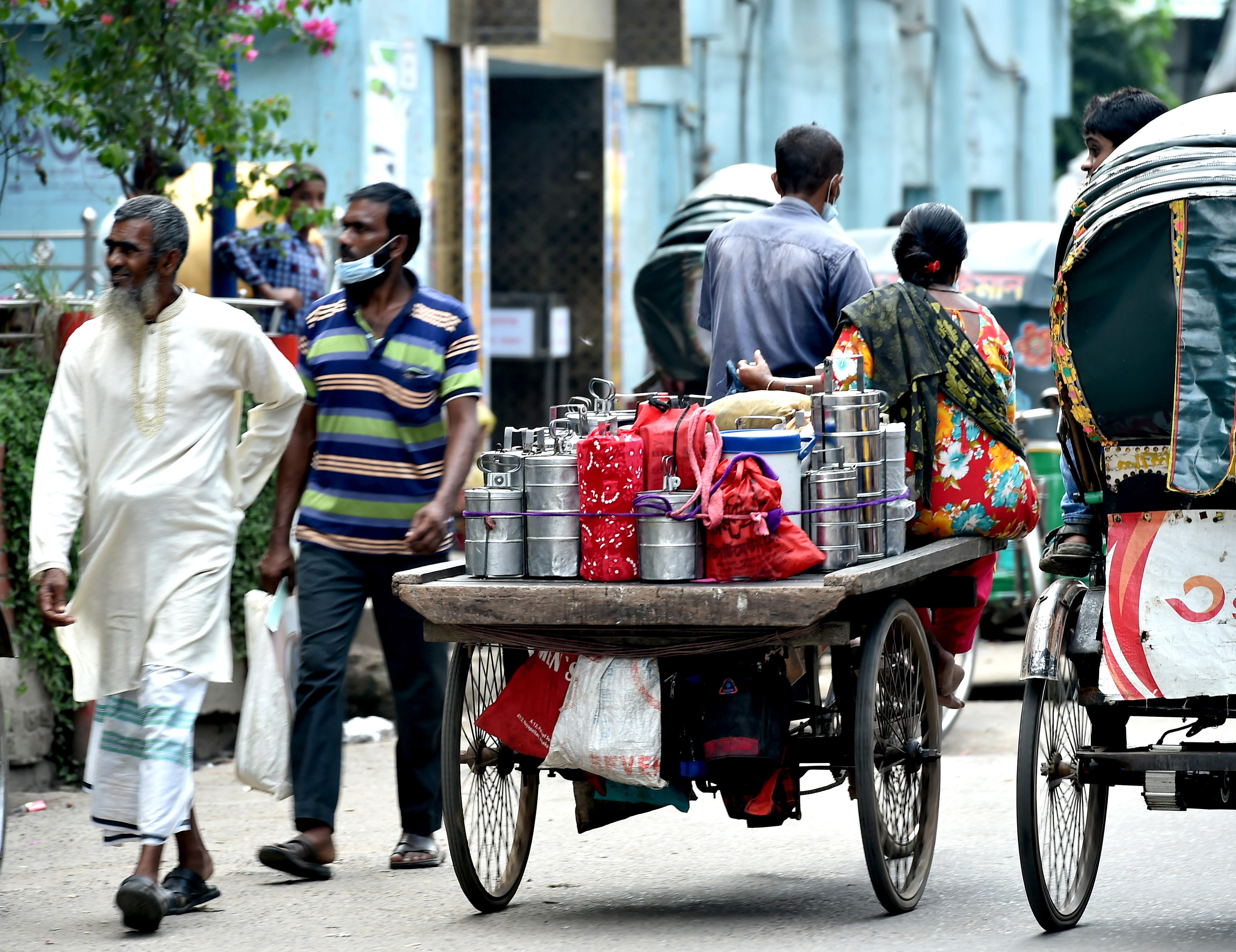 在孟加拉國首都達卡流行着一種名為「達巴瓦拉」的送餐服務，這種服務有悠久的歷史。「達巴瓦拉」，這個源自波斯語的詞語，意思是「送飯盒的人」。在達卡，很多居家妻子親手烹飪的盒飯，每天由「達巴瓦拉」傳遞到為生活打拼的丈夫手中。在訂餐軟件日益發達的今天，這類送餐服務在當地仍然受到歡迎。圖為10月8日，在孟加拉國首都達卡，「達巴瓦拉」乘坐三輪車運送飯盒。（新華社）