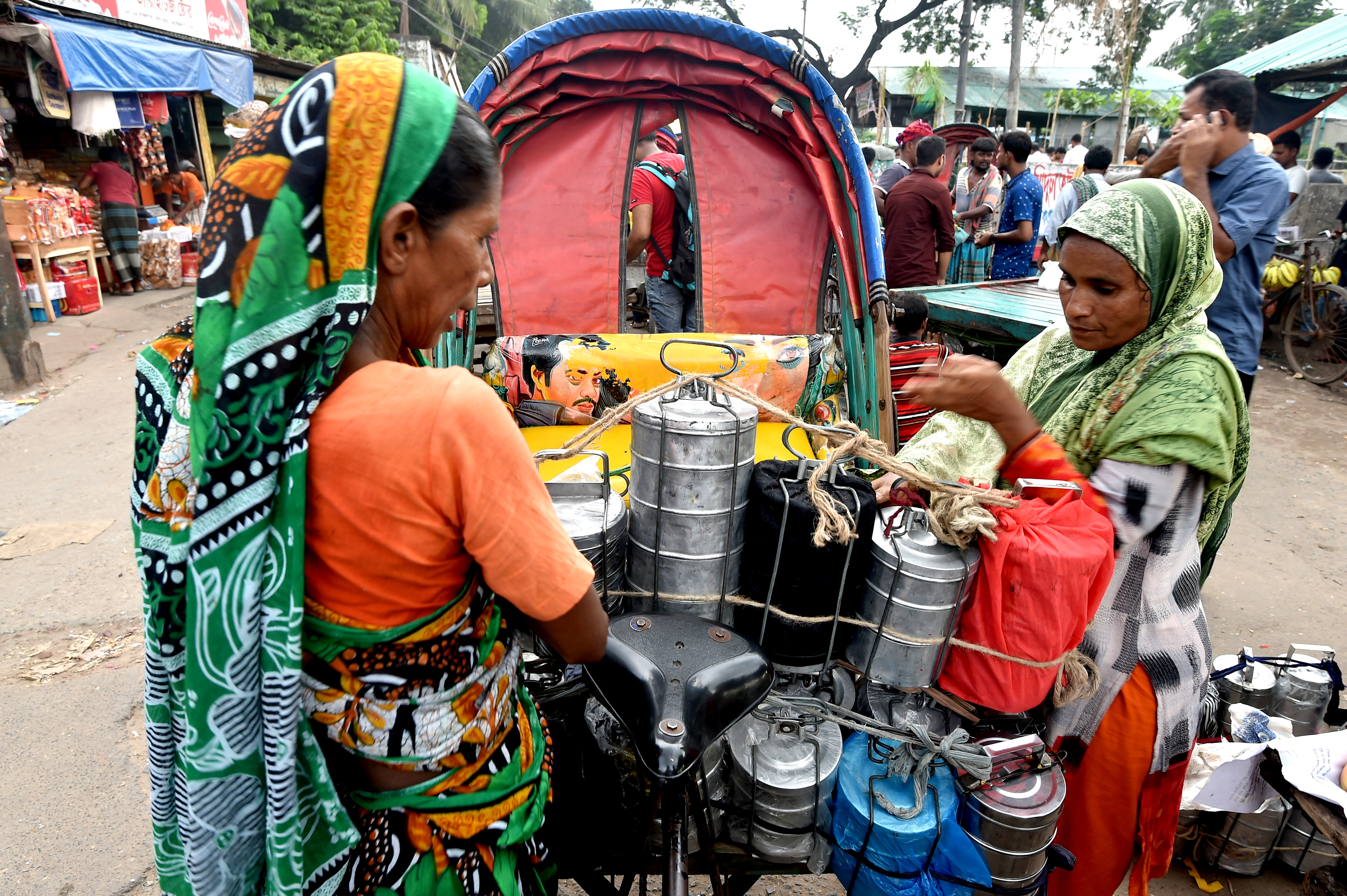 在孟加拉國首都達卡流行着一種名為「達巴瓦拉」的送餐服務，這種服務有悠久的歷史。「達巴瓦拉」，這個源自波斯語的詞語，意思是「送飯盒的人」。在達卡，很多居家妻子親手烹飪的盒飯，每天由「達巴瓦拉」傳遞到為生活打拼的丈夫手中。在訂餐軟件日益發達的今天，這類送餐服務在當地仍然受到歡迎。圖為10月8日，在孟加拉國首都達卡，「達巴瓦拉」用三輪車運送飯盒。（新華社）