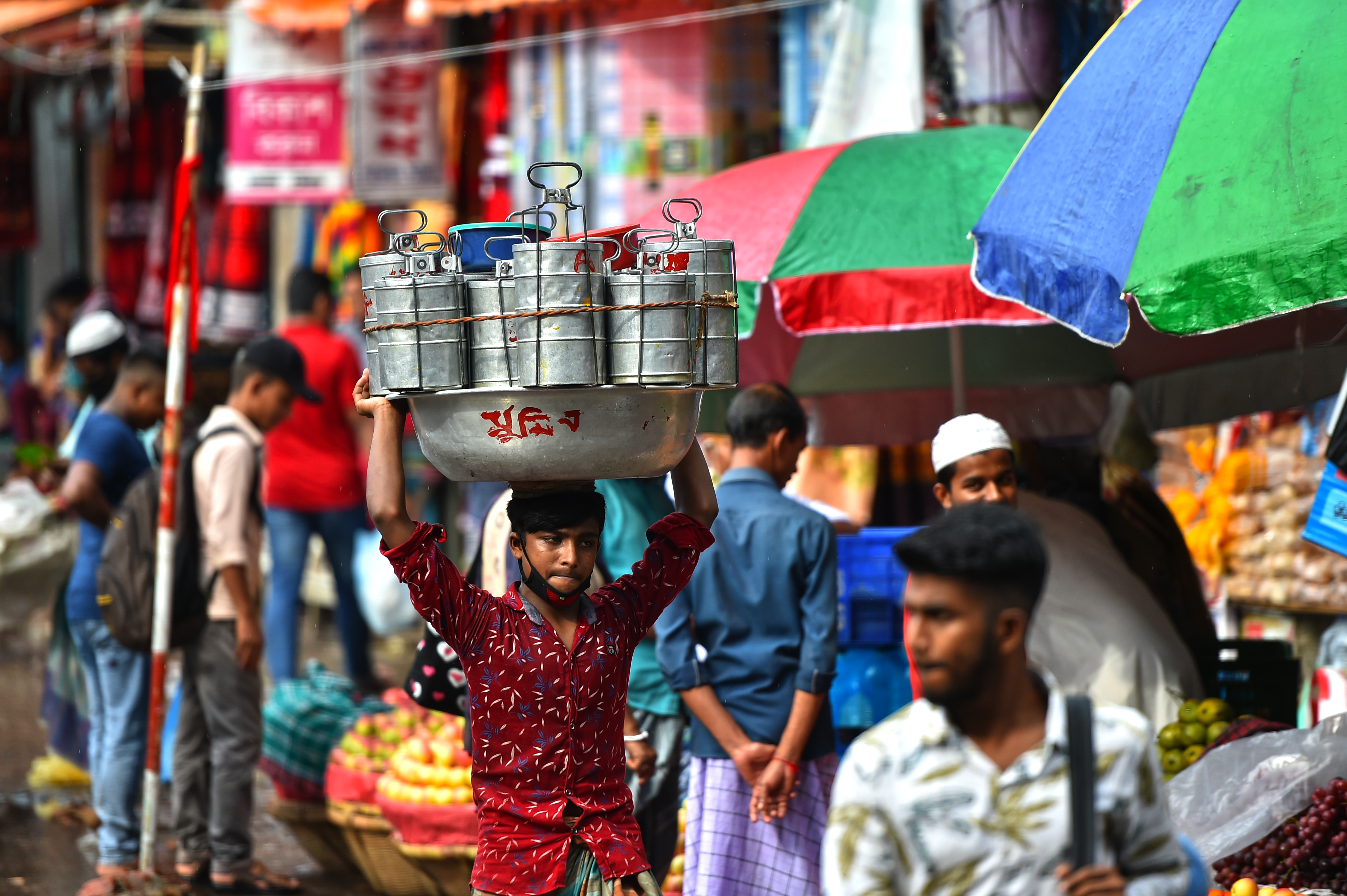 在孟加拉國首都達卡流行着一種名為「達巴瓦拉」的送餐服務，這種服務有悠久的歷史。「達巴瓦拉」，這個源自波斯語的詞語，意思是「送飯盒的人」。在達卡，很多居家妻子親手烹飪的盒飯，每天由「達巴瓦拉」傳遞到為生活打拼的丈夫手中。在訂餐軟件日益發達的今天，這類送餐服務在當地仍然受到歡迎。圖為10月8日，在孟加拉國首都達卡，「達巴瓦拉」頭頂托盤運送飯盒。（新華社）