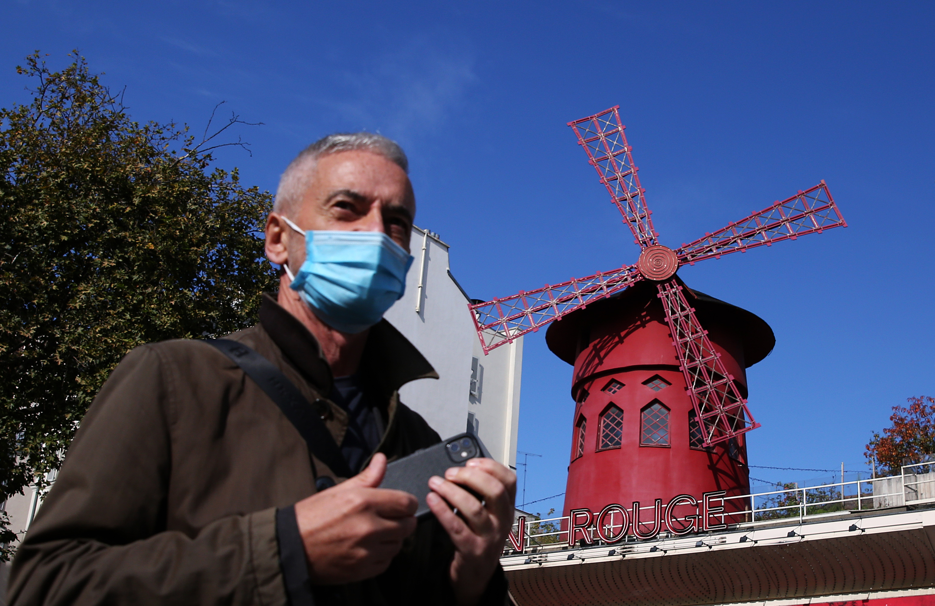 10月14日，一名男子經過法國巴黎紅磨坊歌舞廳。受新冠肺炎疫情影響，紅磨坊自3月13日以來停業至今。新華社
