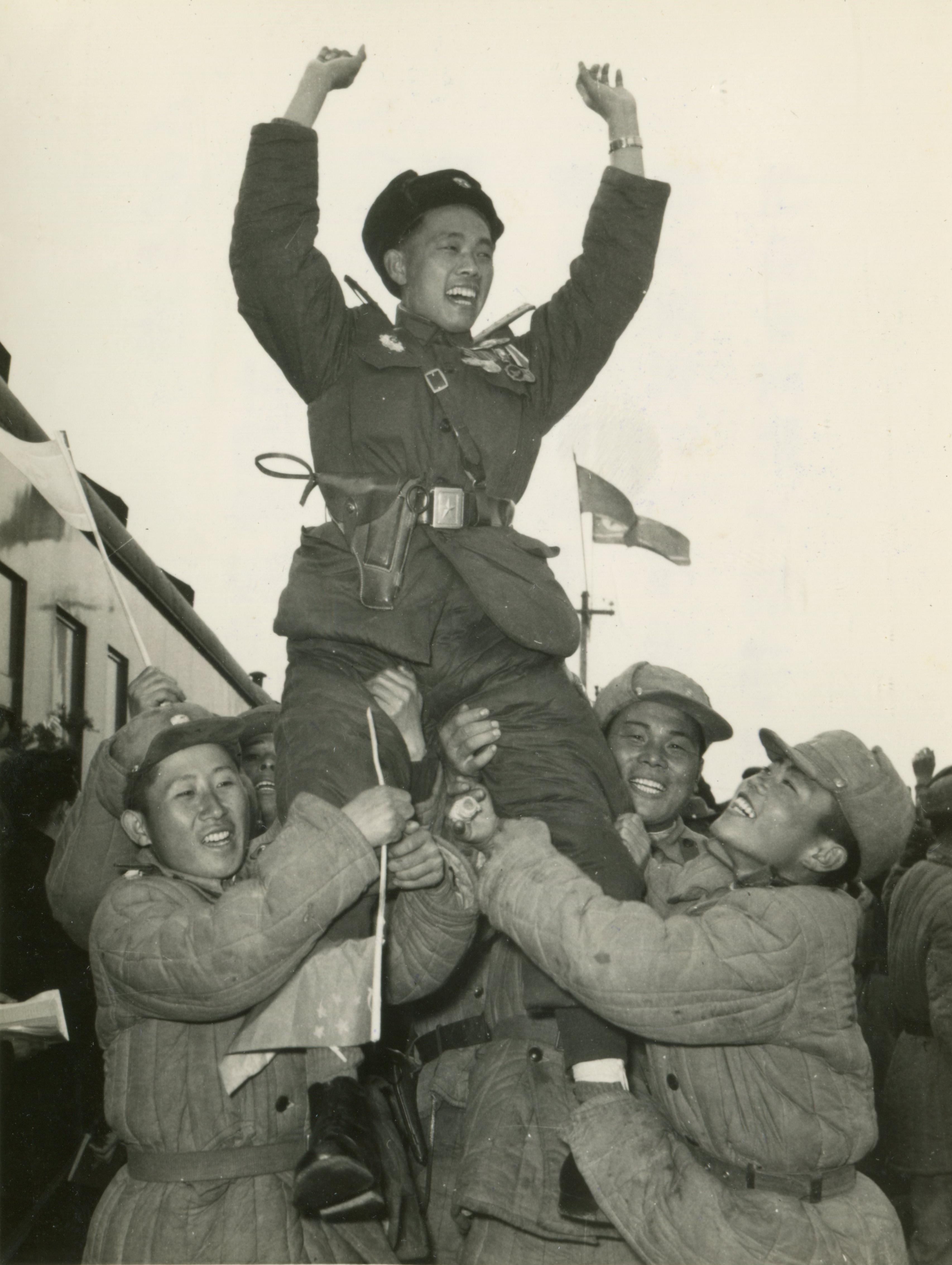 1958年03月17日 志願軍首批歸國部隊歸國途中，3月16日到達新義州，朝鮮官員把志願軍抬在肩上。（資料圖片）