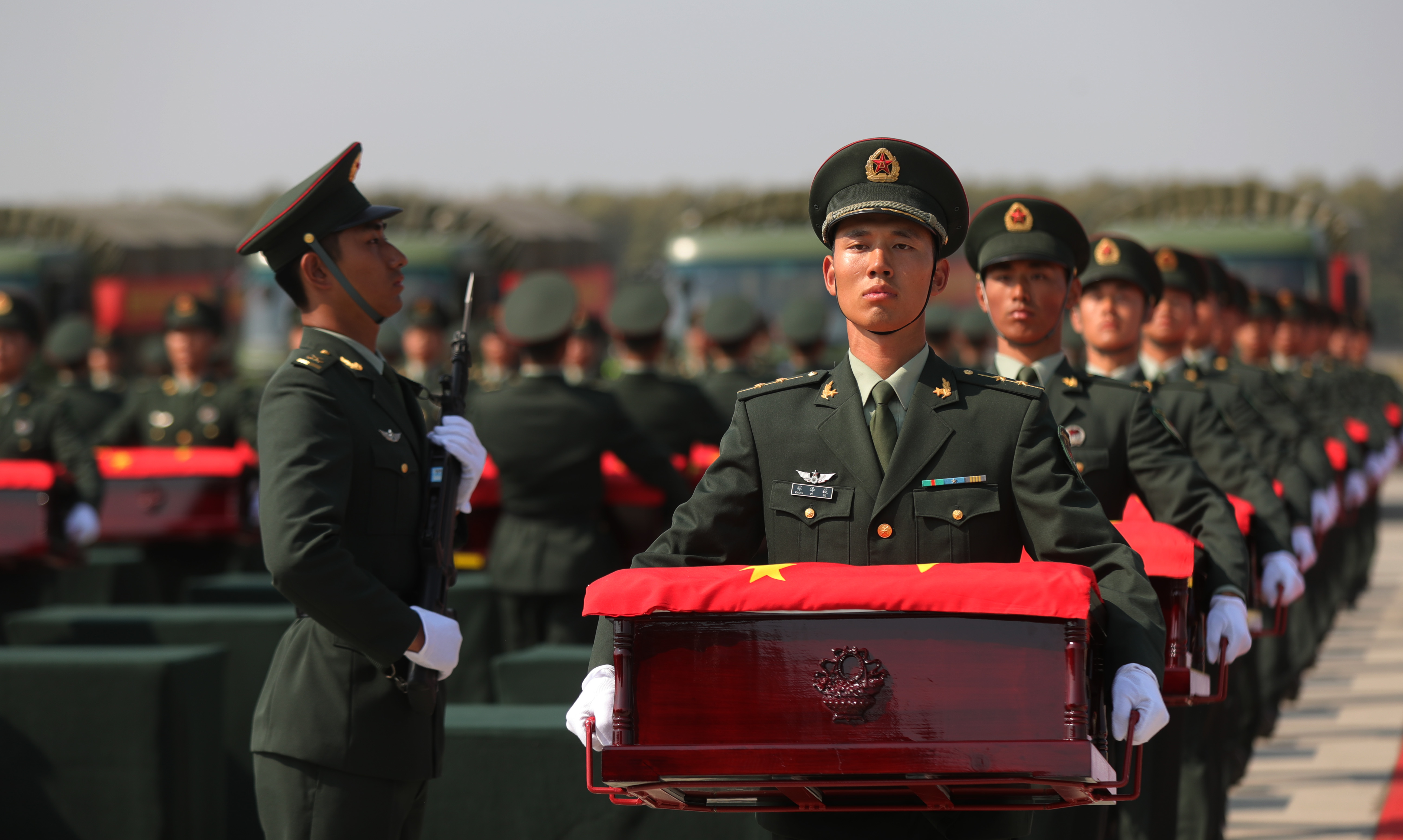 9月27日，在瀋陽桃仙國際機場，禮兵將殮放志願軍烈士遺骸的棺槨準備護送至軍用車輛。（資料圖片）