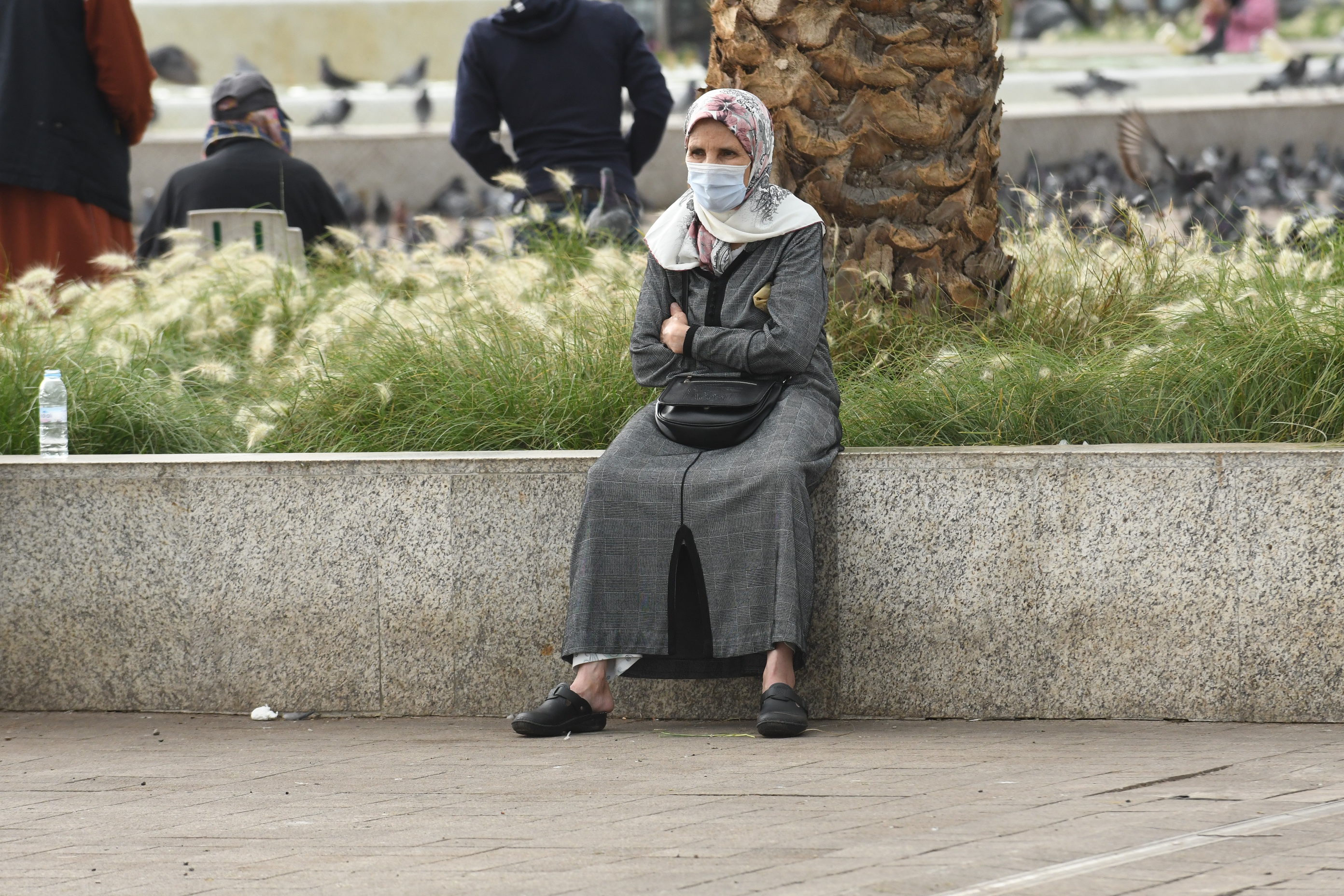  10月22日，一名戴口罩的女子坐在摩洛哥卡薩布蘭卡街頭。（新華社）