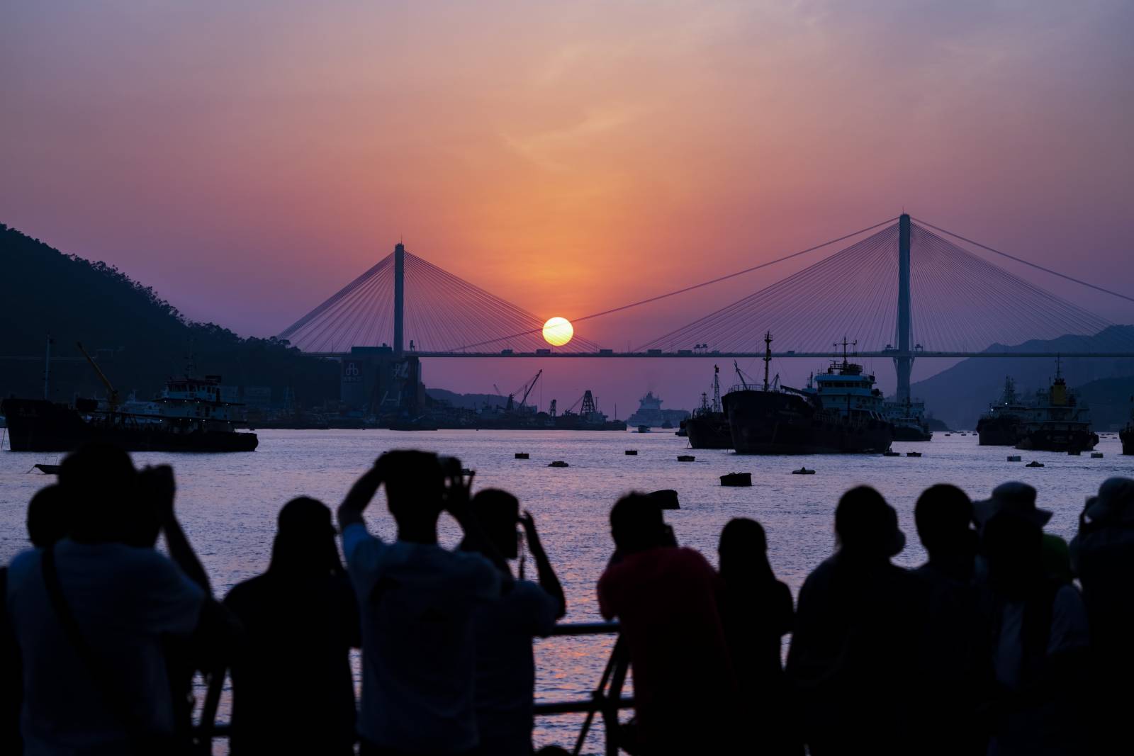 10月26日傍晚，數百名攝影愛好者抓住今年最後的機會，在香港荃灣海濱公園拍攝汀九橋日落。