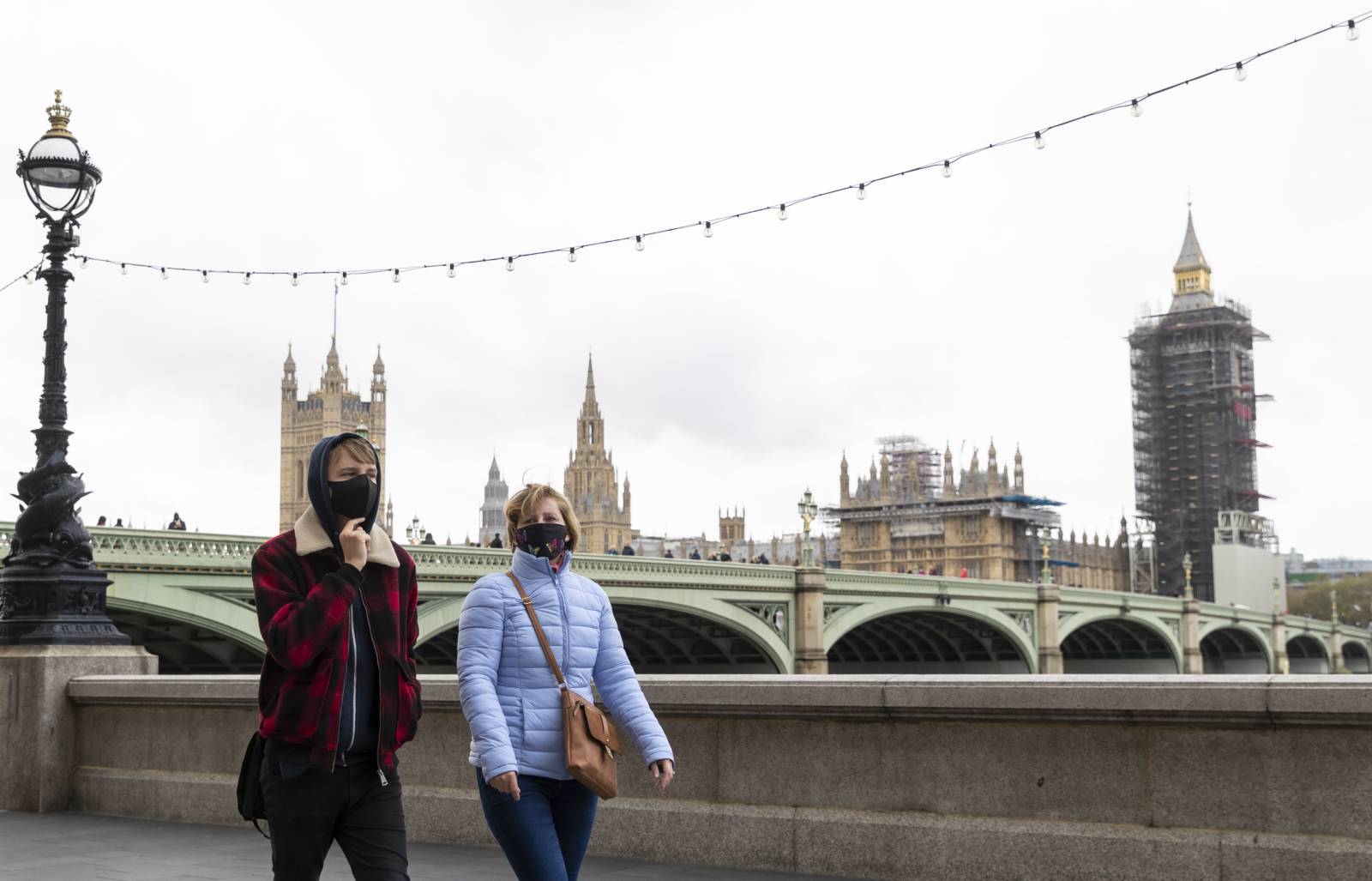 10月28日，戴口罩的人們在英國倫敦泰晤士河畔行走。（新華社）