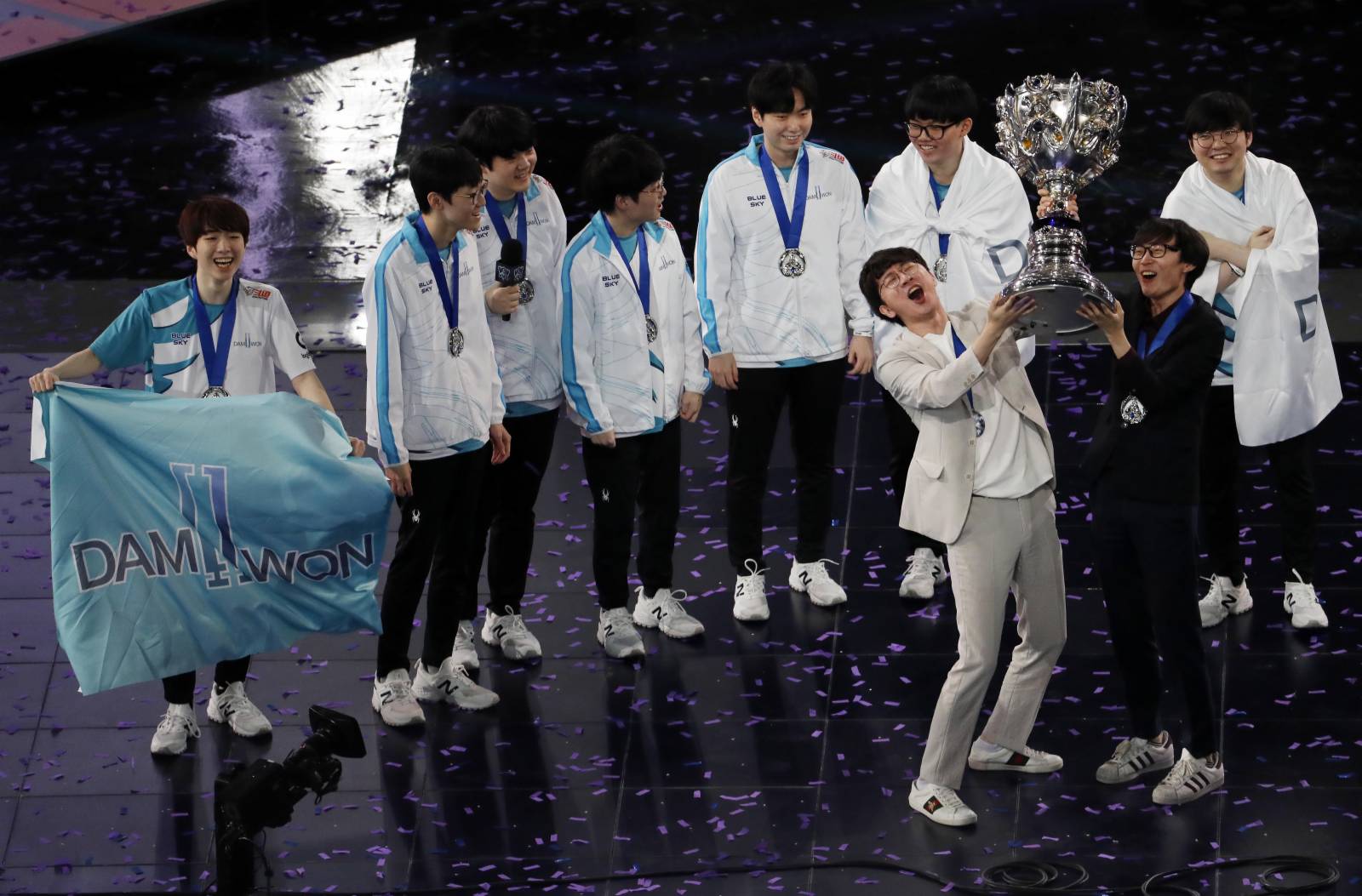圖為韓國DWG戰隊隊員舉起冠軍獎盃。（中新社）