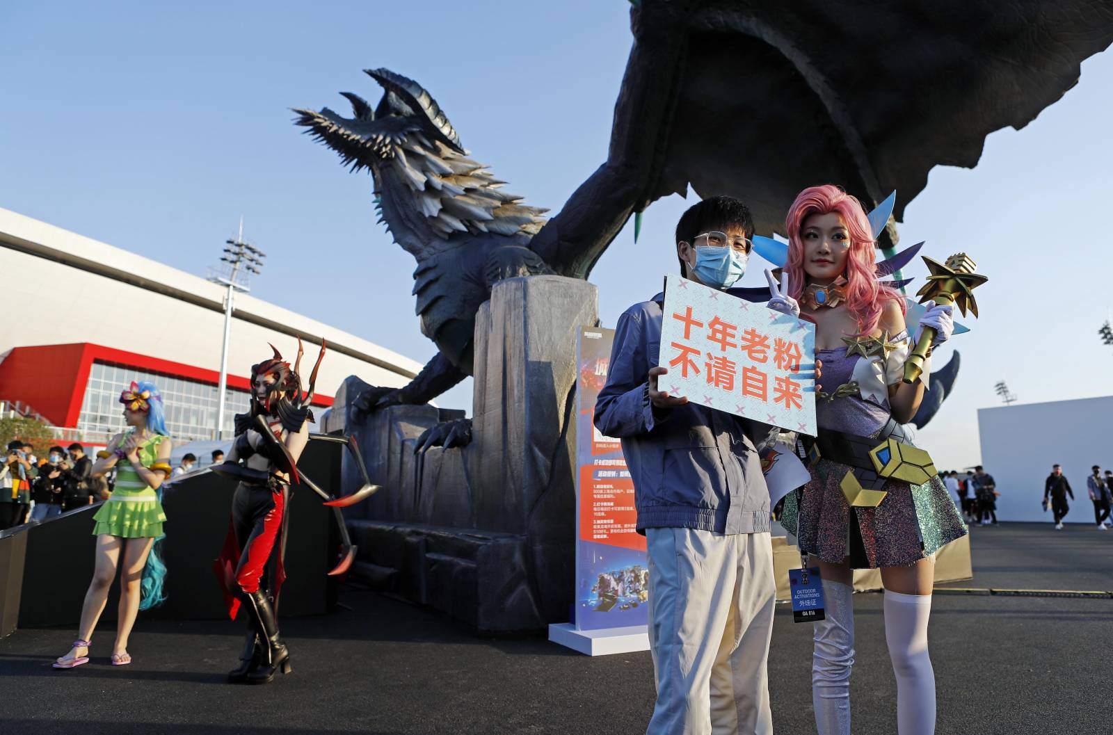 觀眾與英雄聯盟遊戲人物合影留念。（中新社）